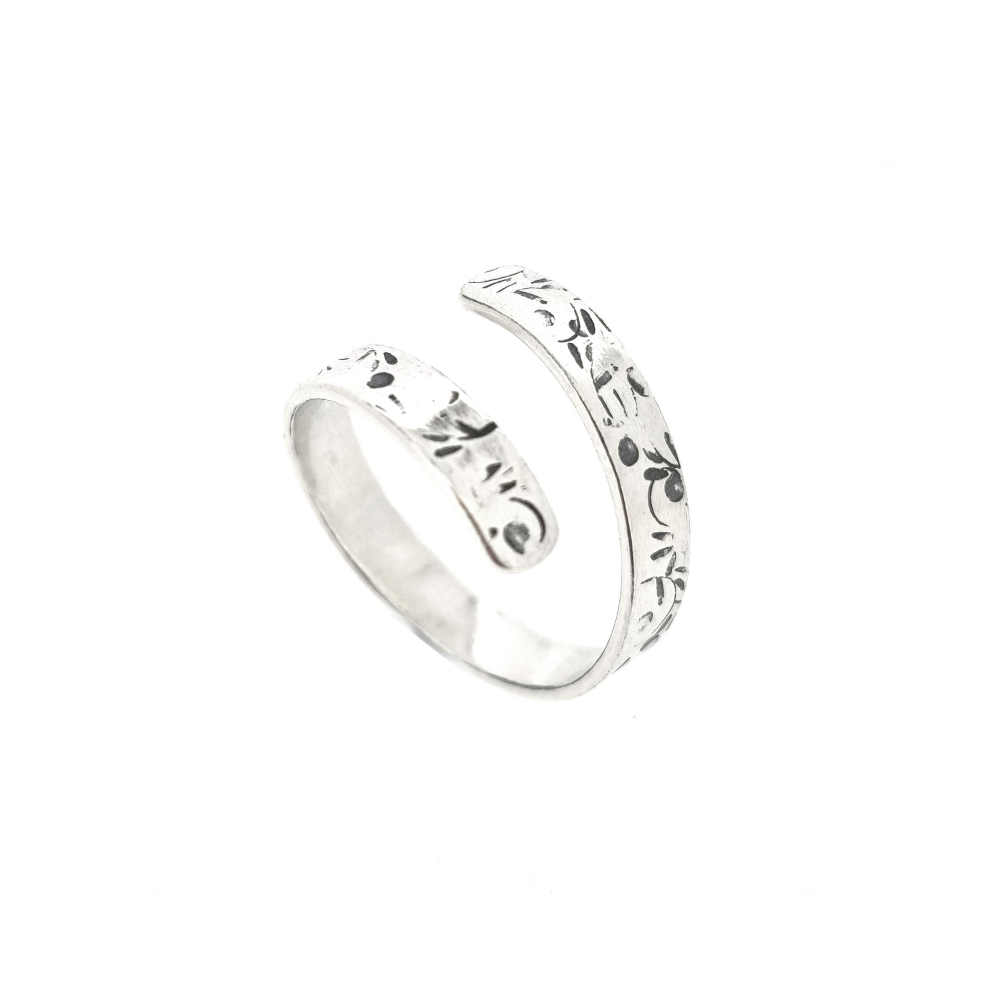 A flat silver wrap ring with leaf, bud and stalk pattern.