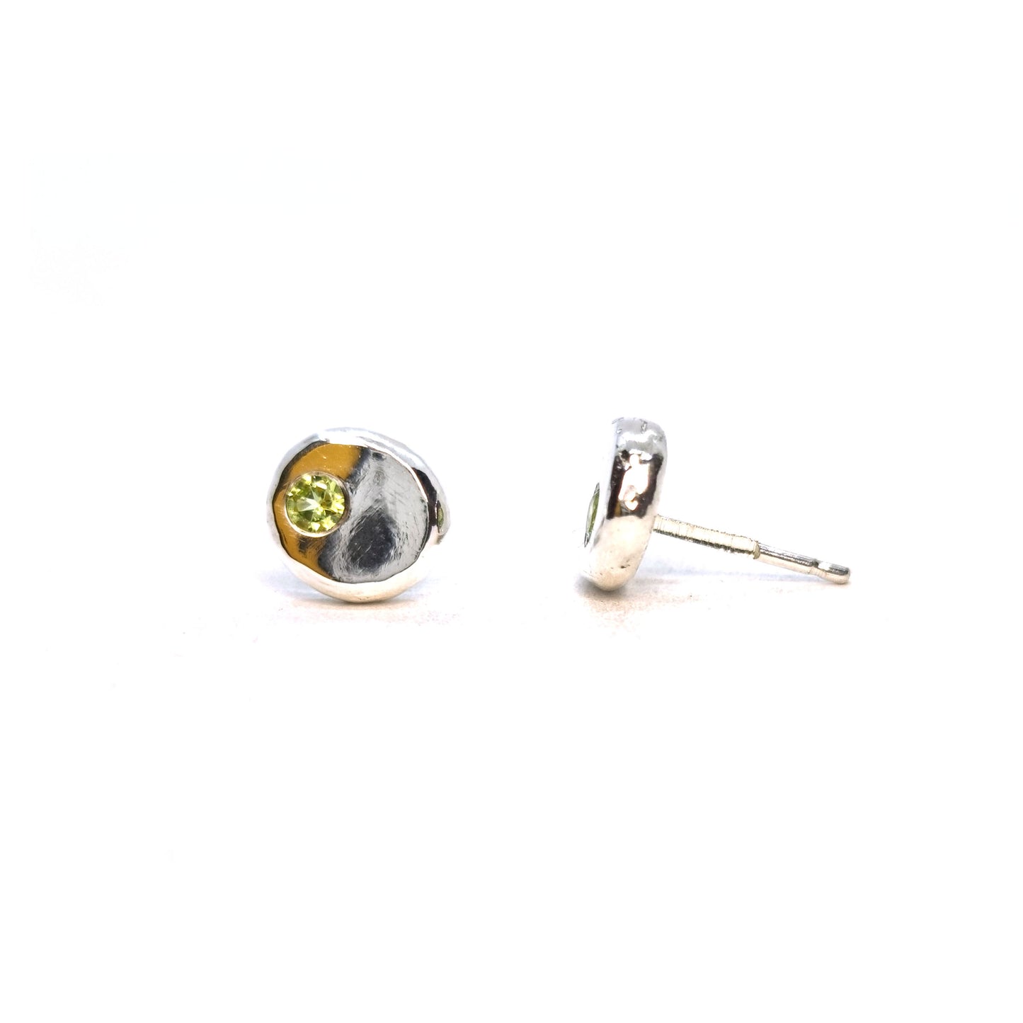 Silver round flat 'pebble' stud earrings set with pale green peridot gemstones.