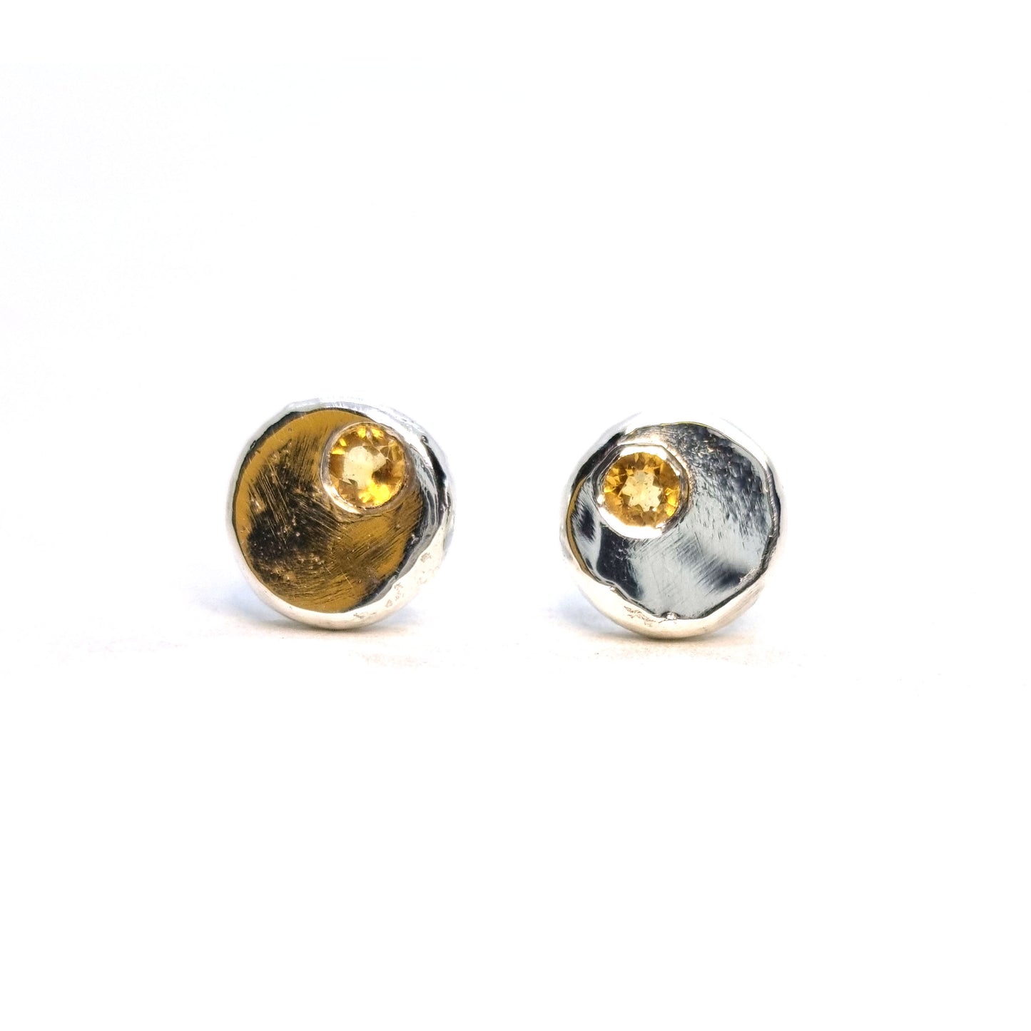 Round silver pebble stud earrings with yellow citrine gemstones flush set off-centre.