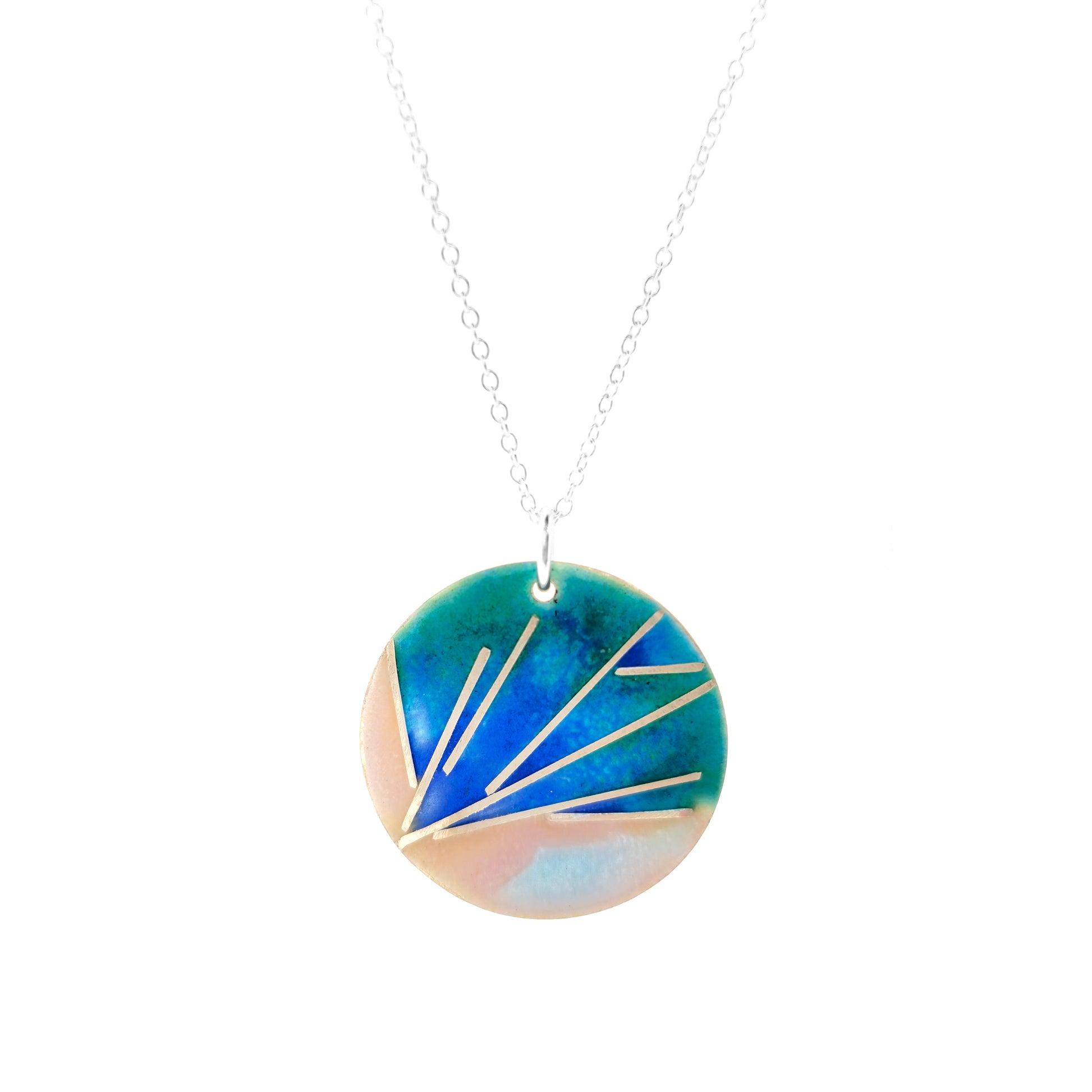 A round silver pendant with a spray of silver lines and blue, pink, and green enamel. On a silver chain.