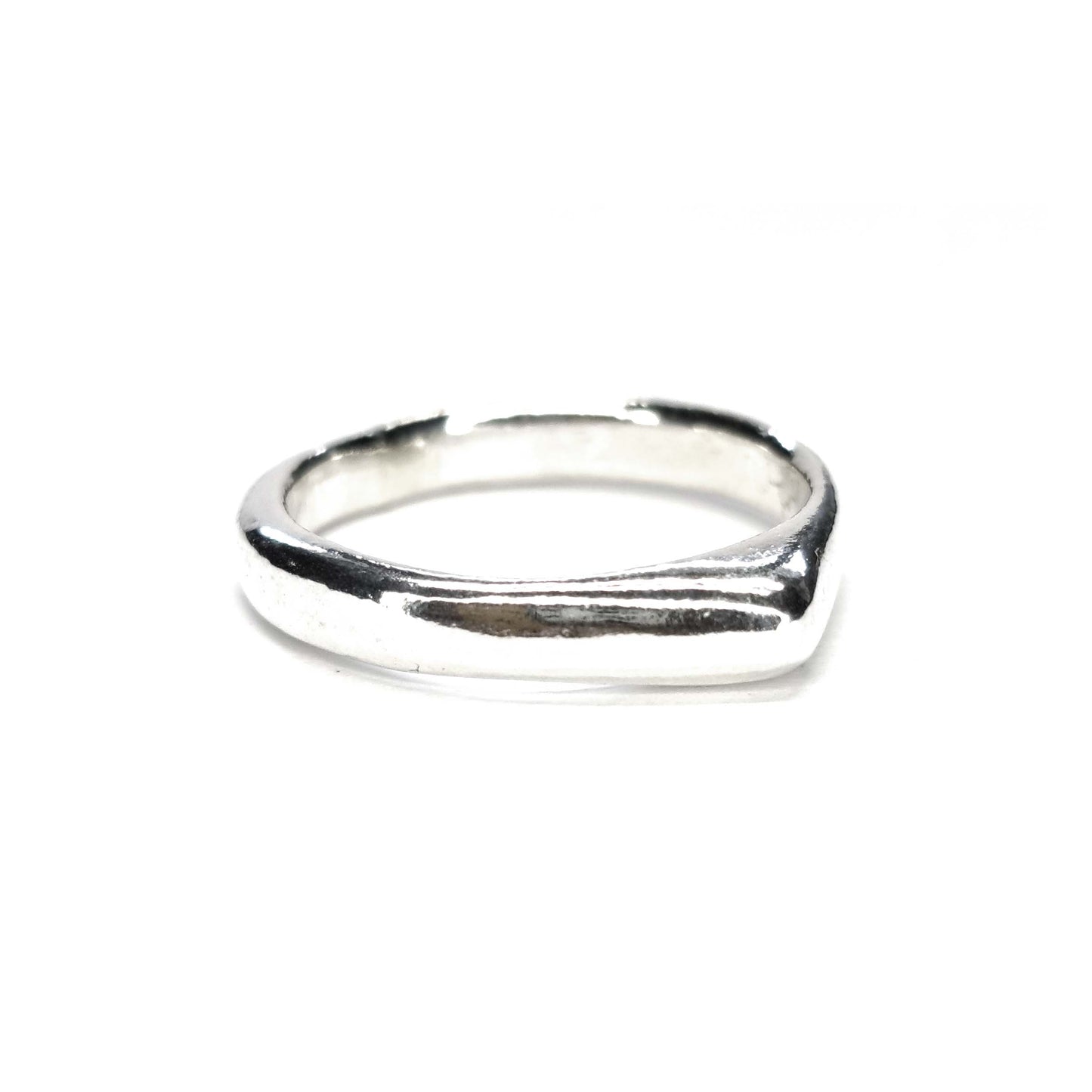 A silver ring which comes to a soft point at the top.