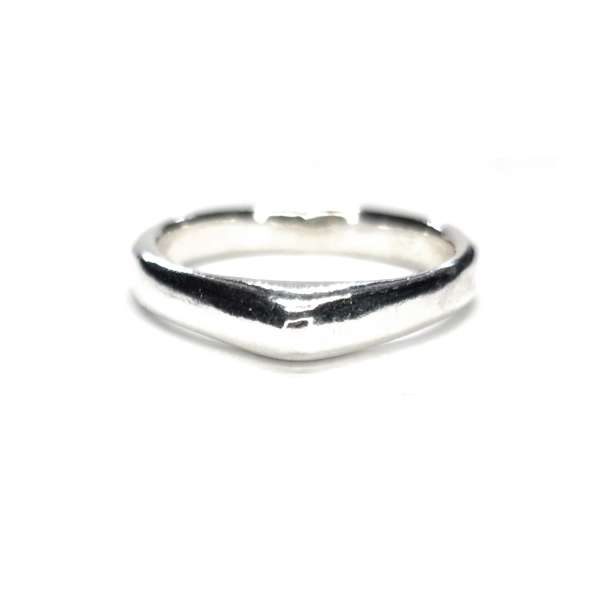 A silver ring which comes to a soft point at the top.
