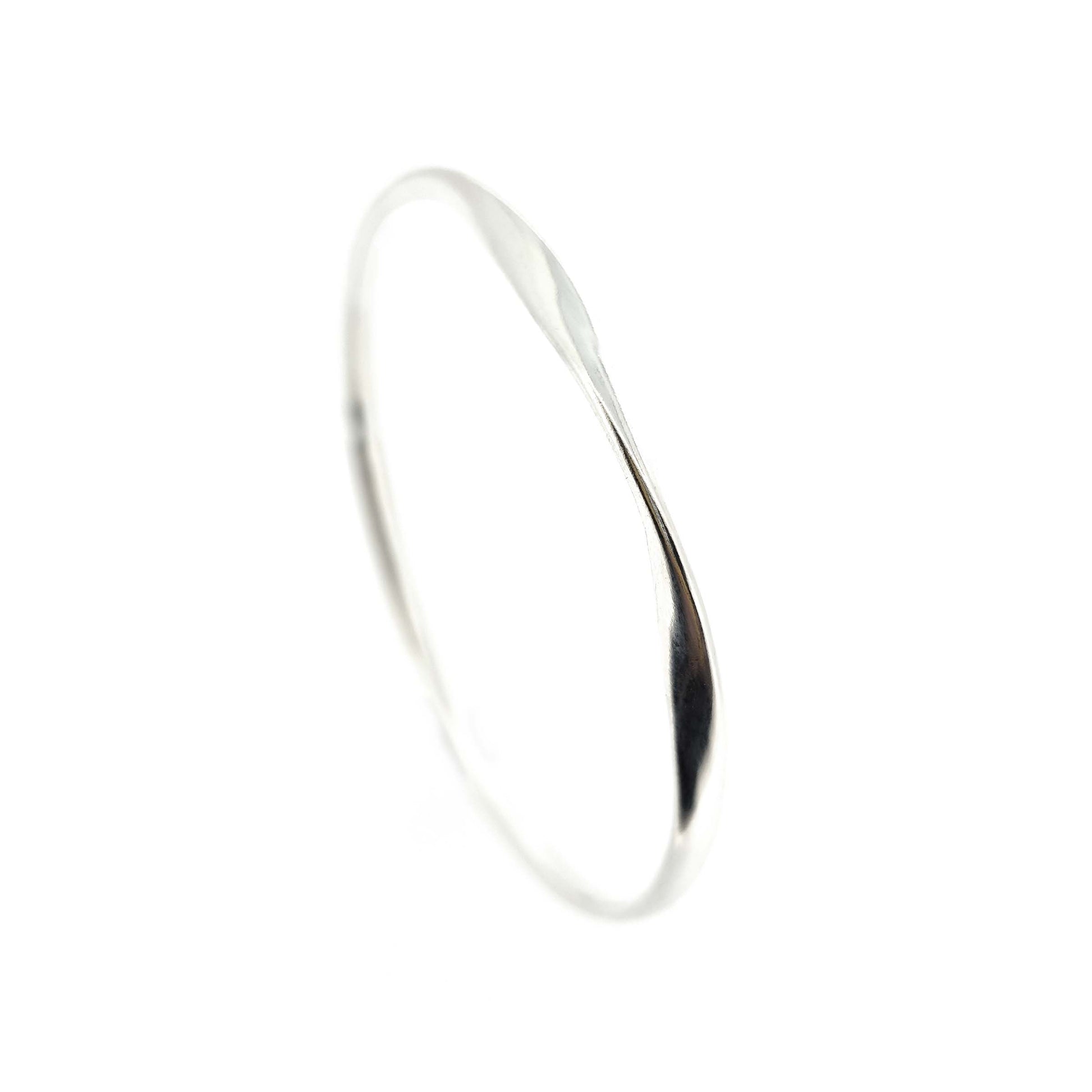 Round silver bangle with oval profile and a twist in one part.