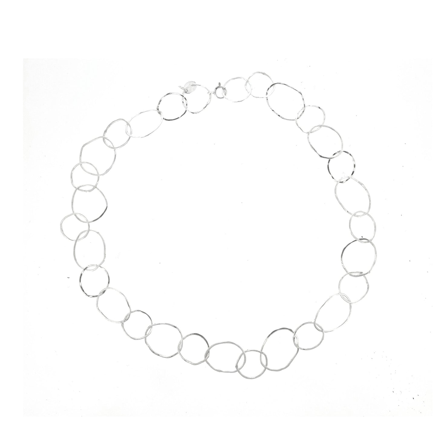 A silver necklace made of organic style circular links of various sizes.