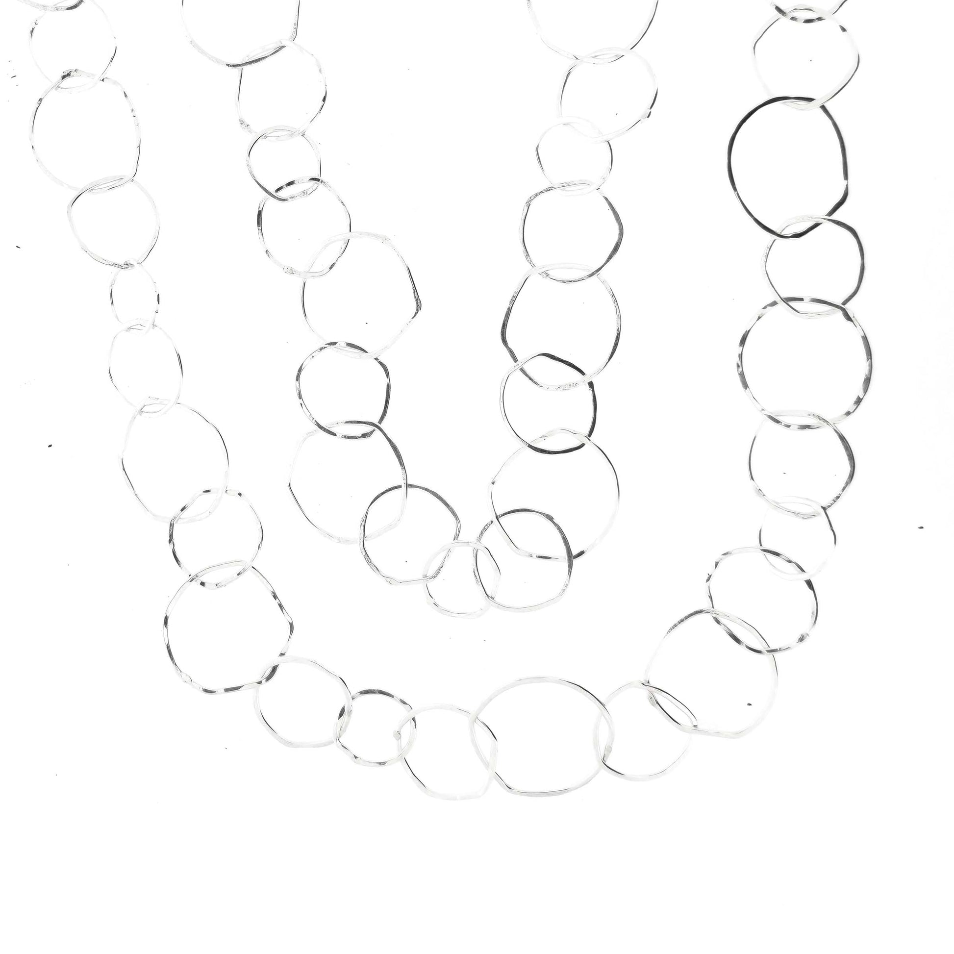 Silver necklace with rustic interlocking circular links on a white back ground