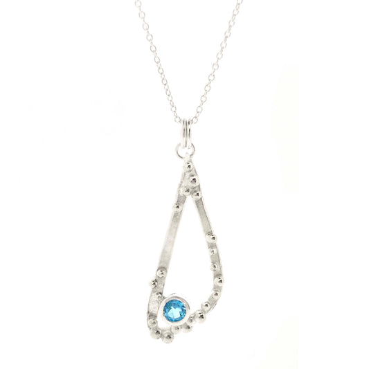 Silver asymmetrical soft open triangle pendant with silver balls and a blue topaz gemstone on a silver chain. Shown on a white background.