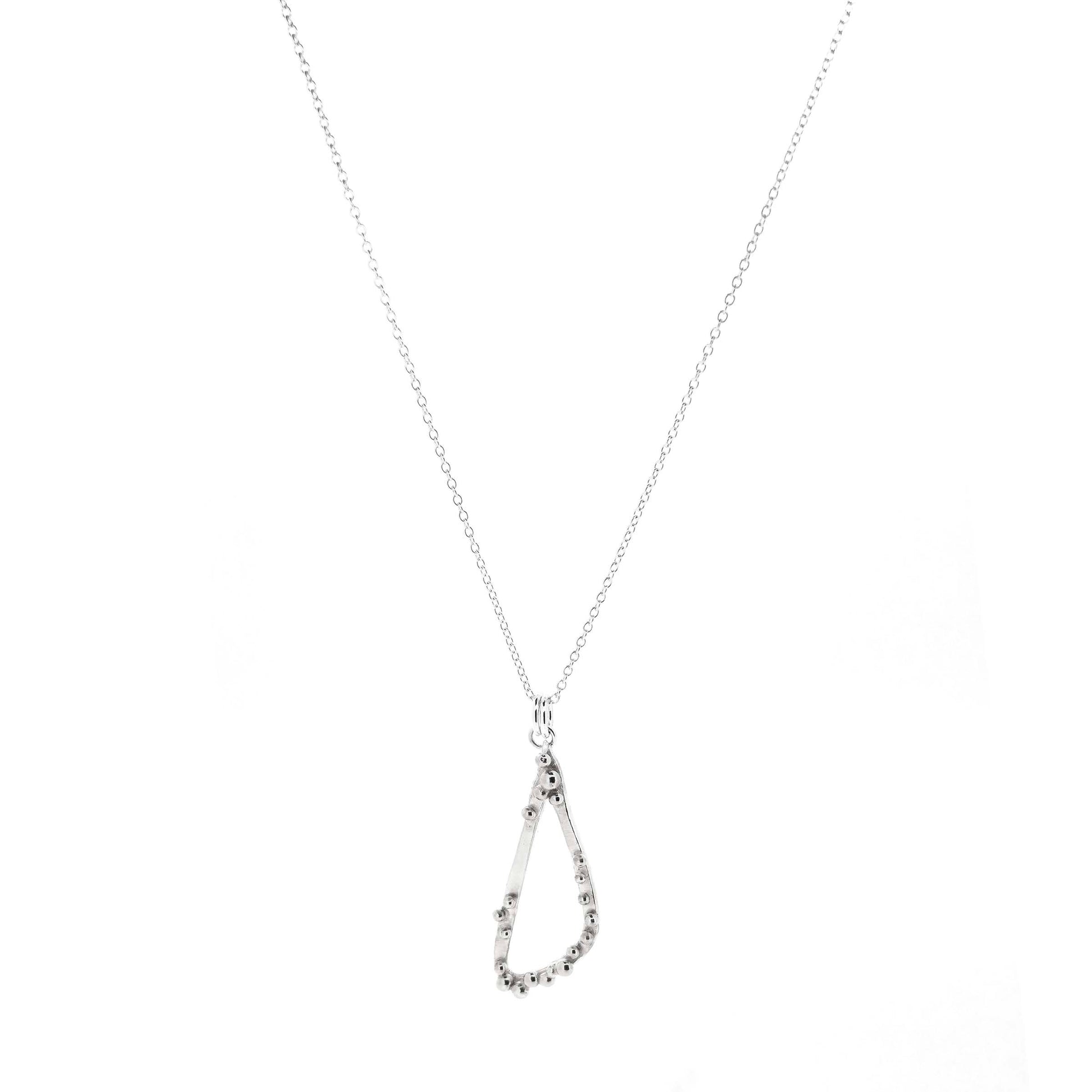 A silver asymmetrical pendant with a soft open triangle shape and silver balls, suspended from a silver chain. Shown on a white background.
