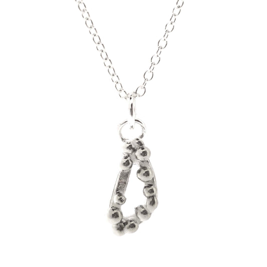 Silver asymmetric open triangle pendant with silver balls on a silver chain. Shown on a white background.
