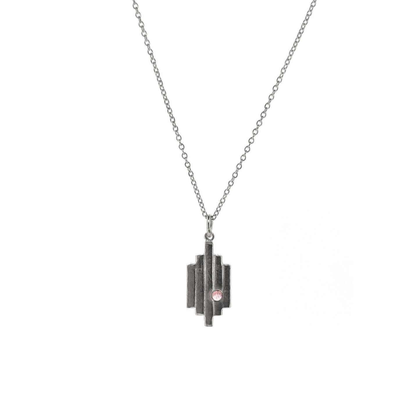 A silver Art Deco style pendant with 5 lines are a pink tourmaline gemstone set off center. On a silver chain.