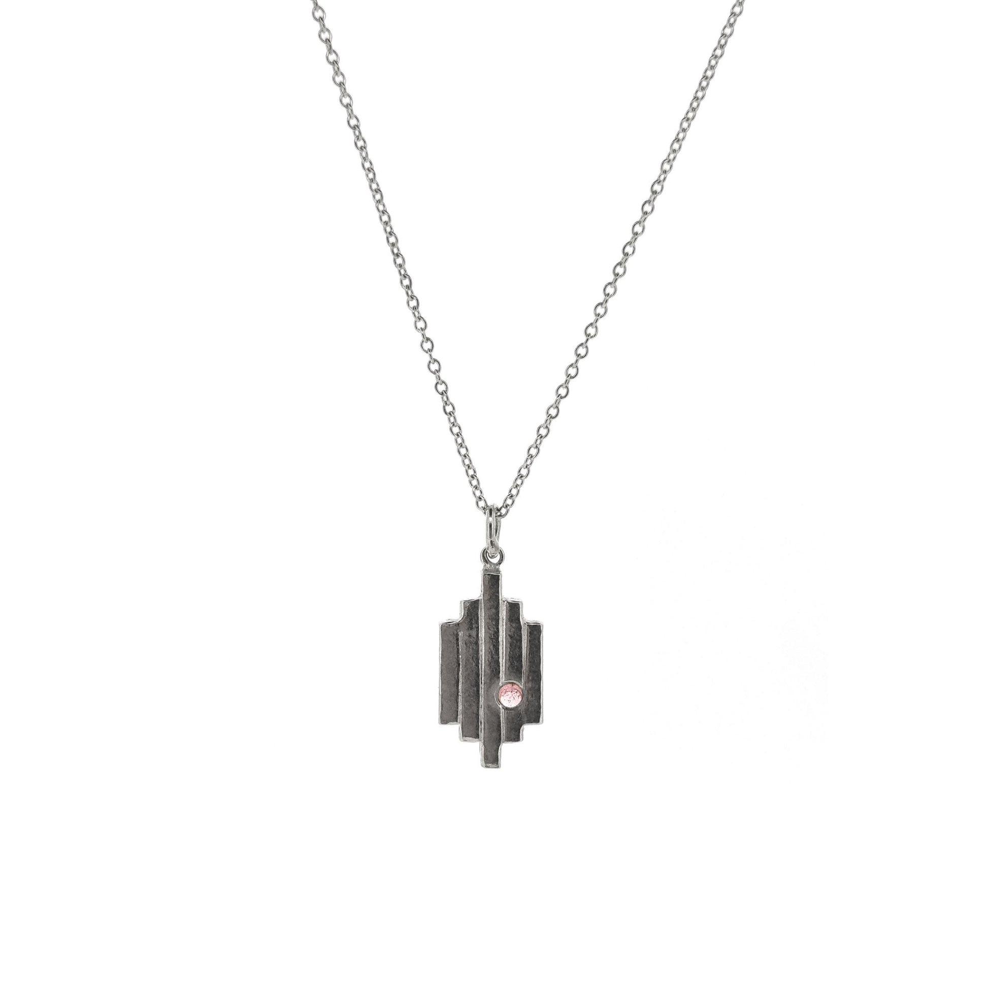 A silver Art Deco style pendant with 5 lines are a pink tourmaline gemstone set off center. On a silver chain.