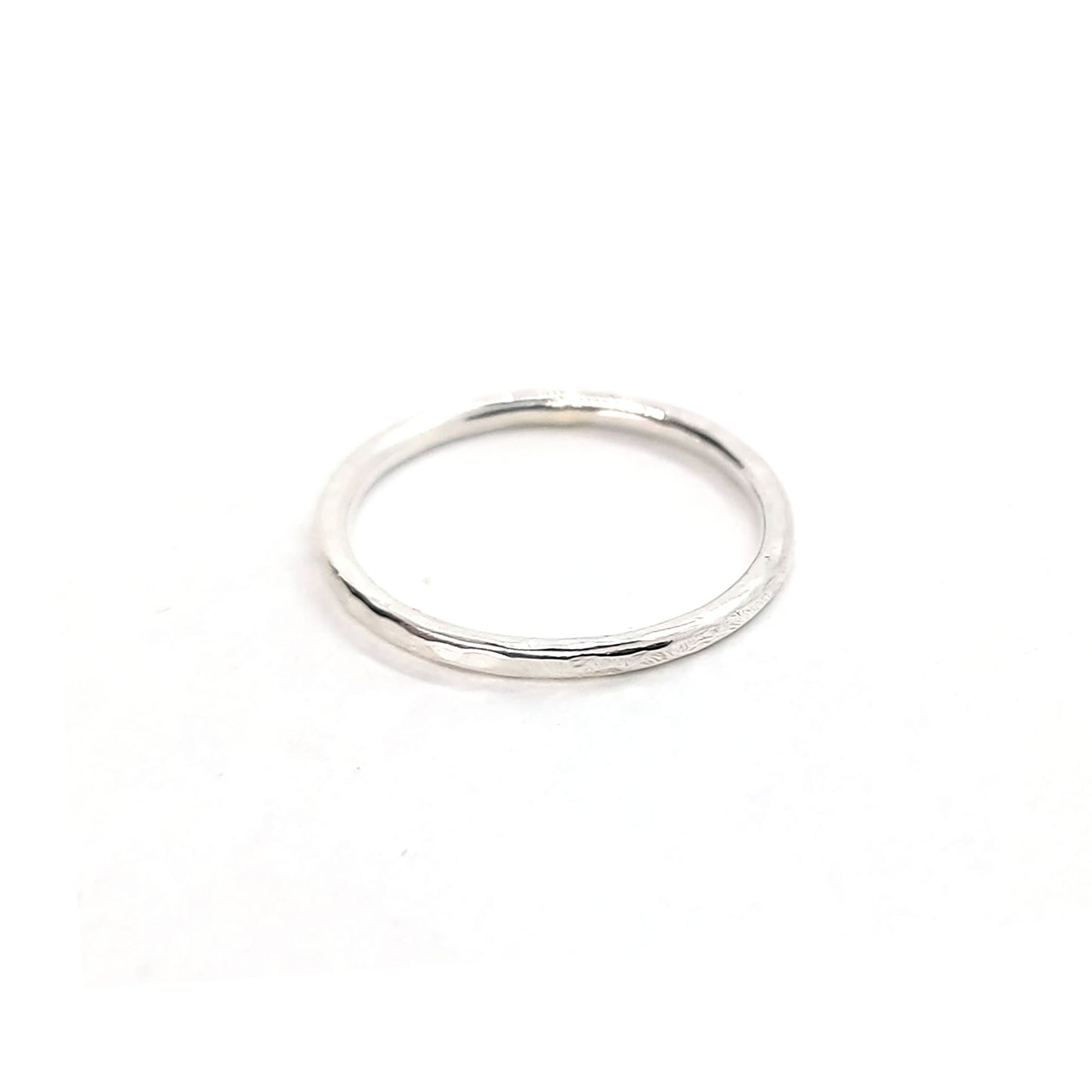 A thin silver stacking ring with a hammered finish.