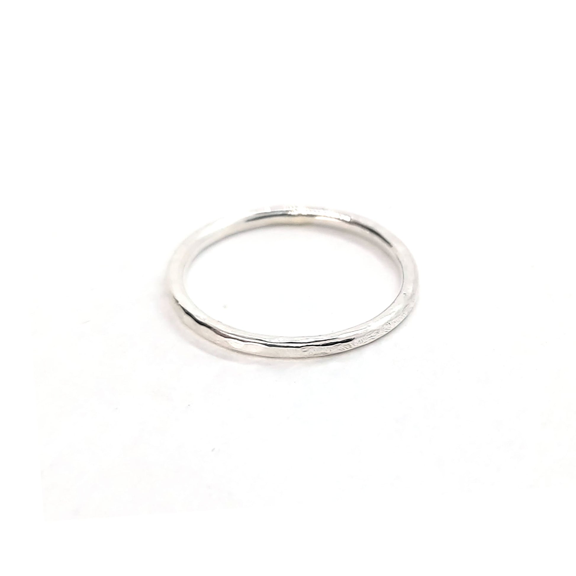 A thin silver stacking ring with a hammered finish.