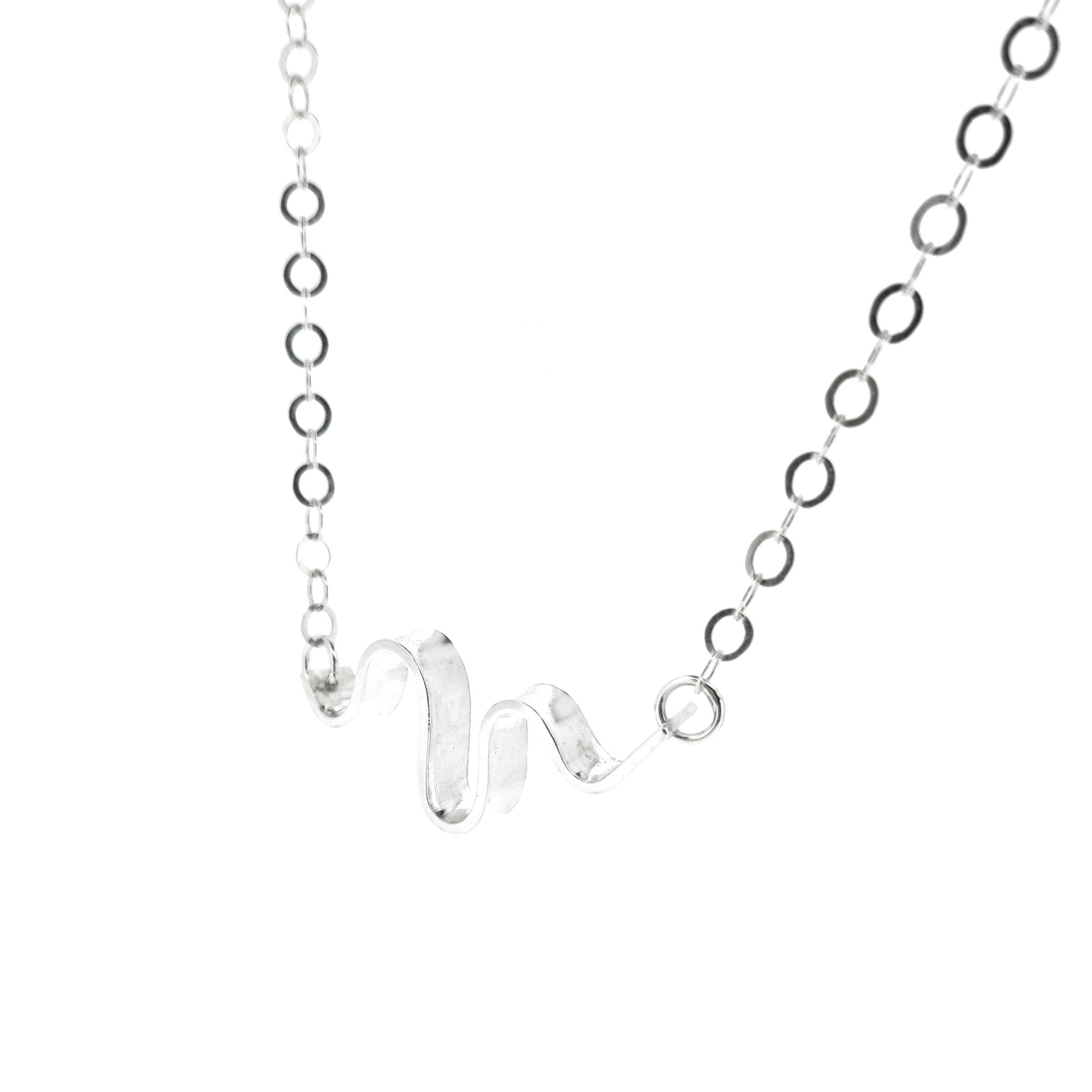 A silver necklace with an open chain and a wave of silver at the center.