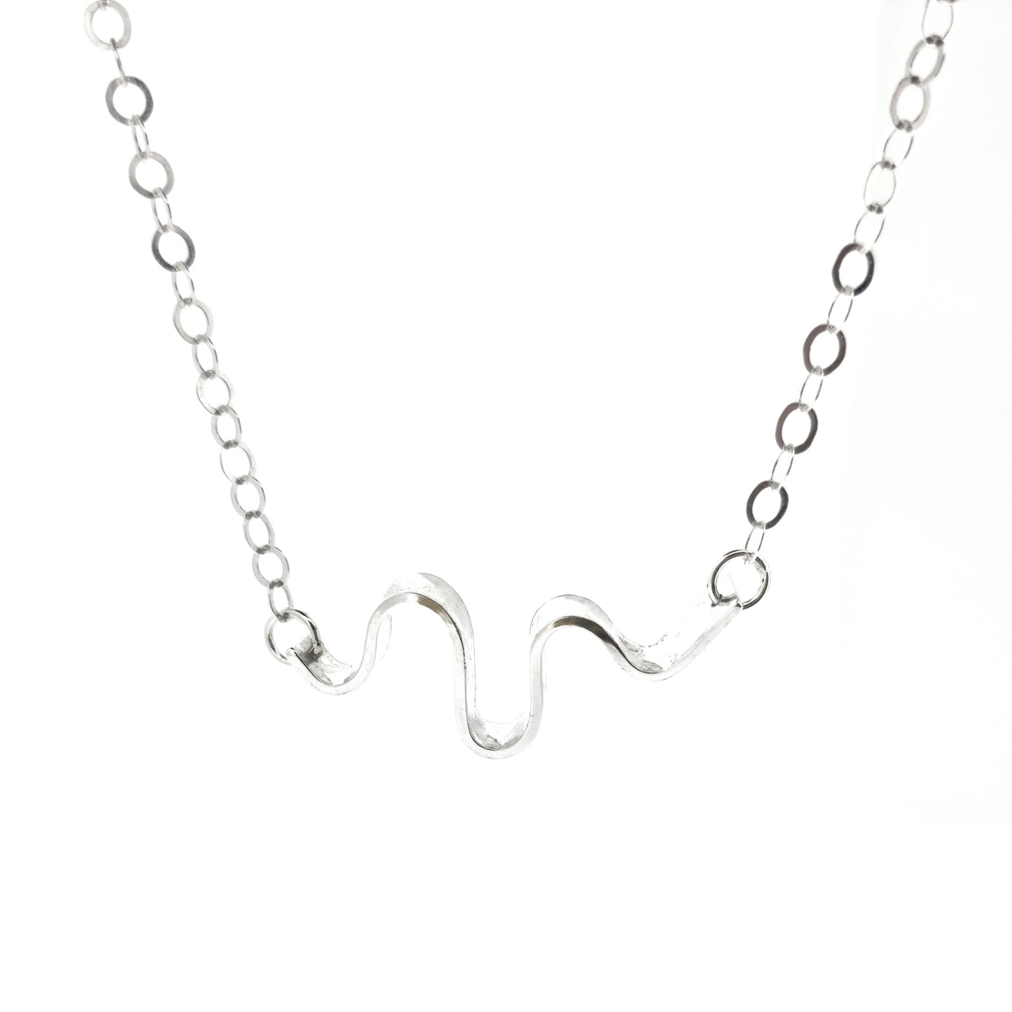 A silver necklace with an open chain and a wave of silver at the center.