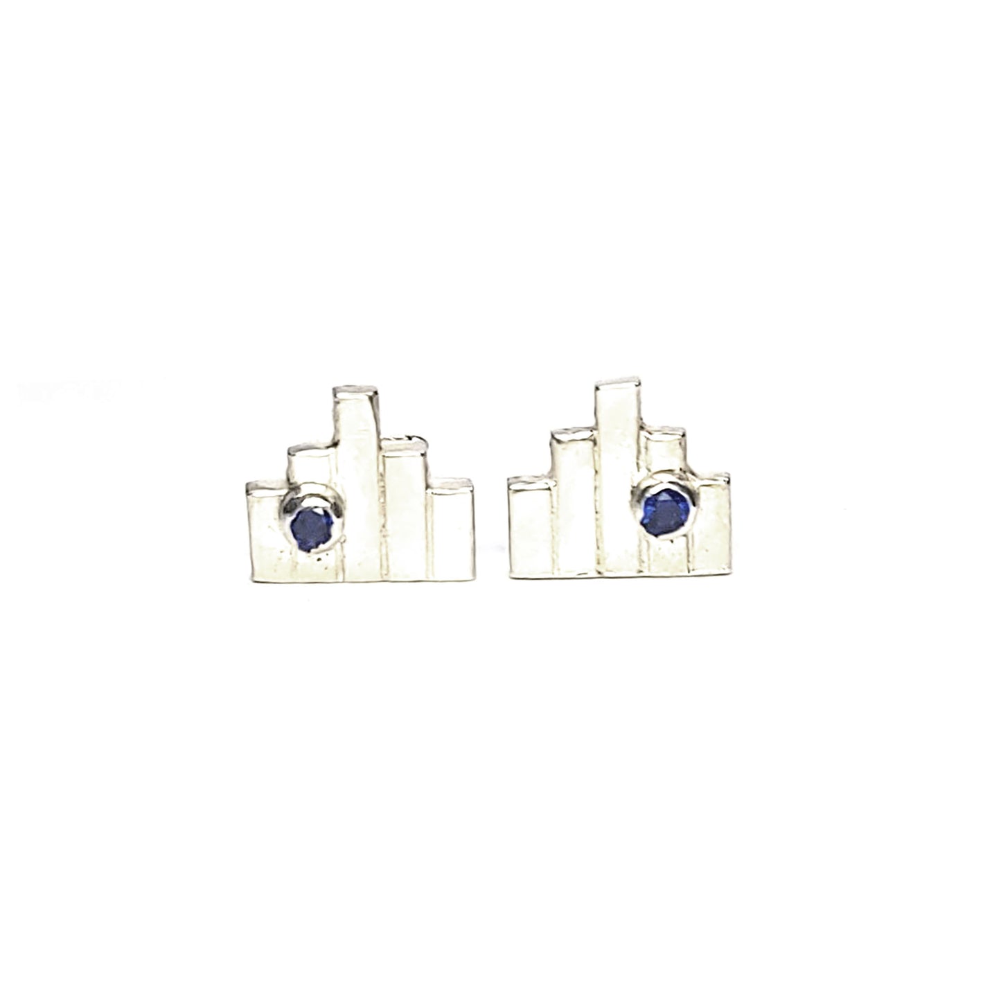 Silver Art Deco style stud earrings with 5 silver lines and off-centre dark blue sapphires.
