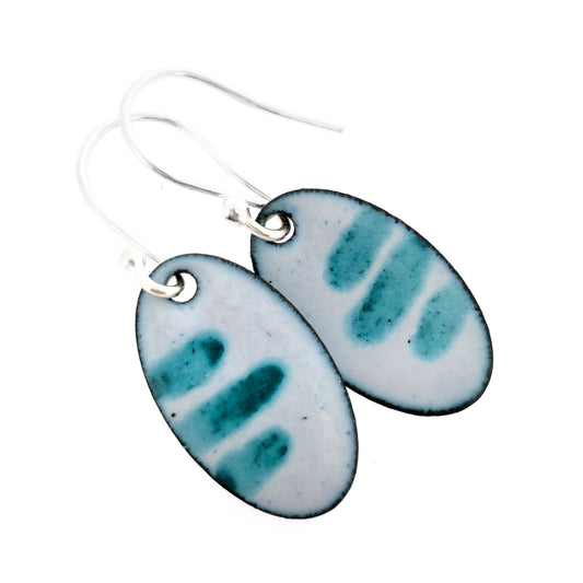 Pair of oval enamel earrings with teal stripe pattern on a light grey background with silver ear hooks on a white background