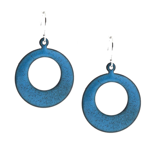 Enamel drop earrings featuring an open circle with teal blue enamel and a dusting of red enamel. On silver ear hooks.
