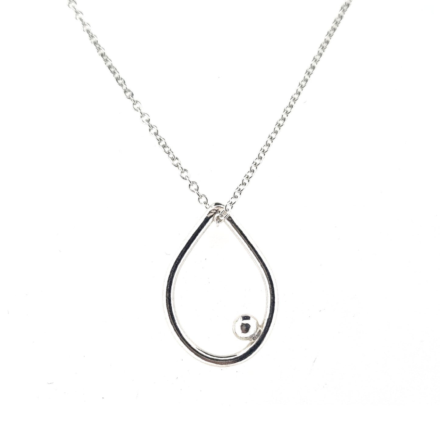 A silver open teardrop shaped pendant with an off-centre ball. On a silver chain. Medium.