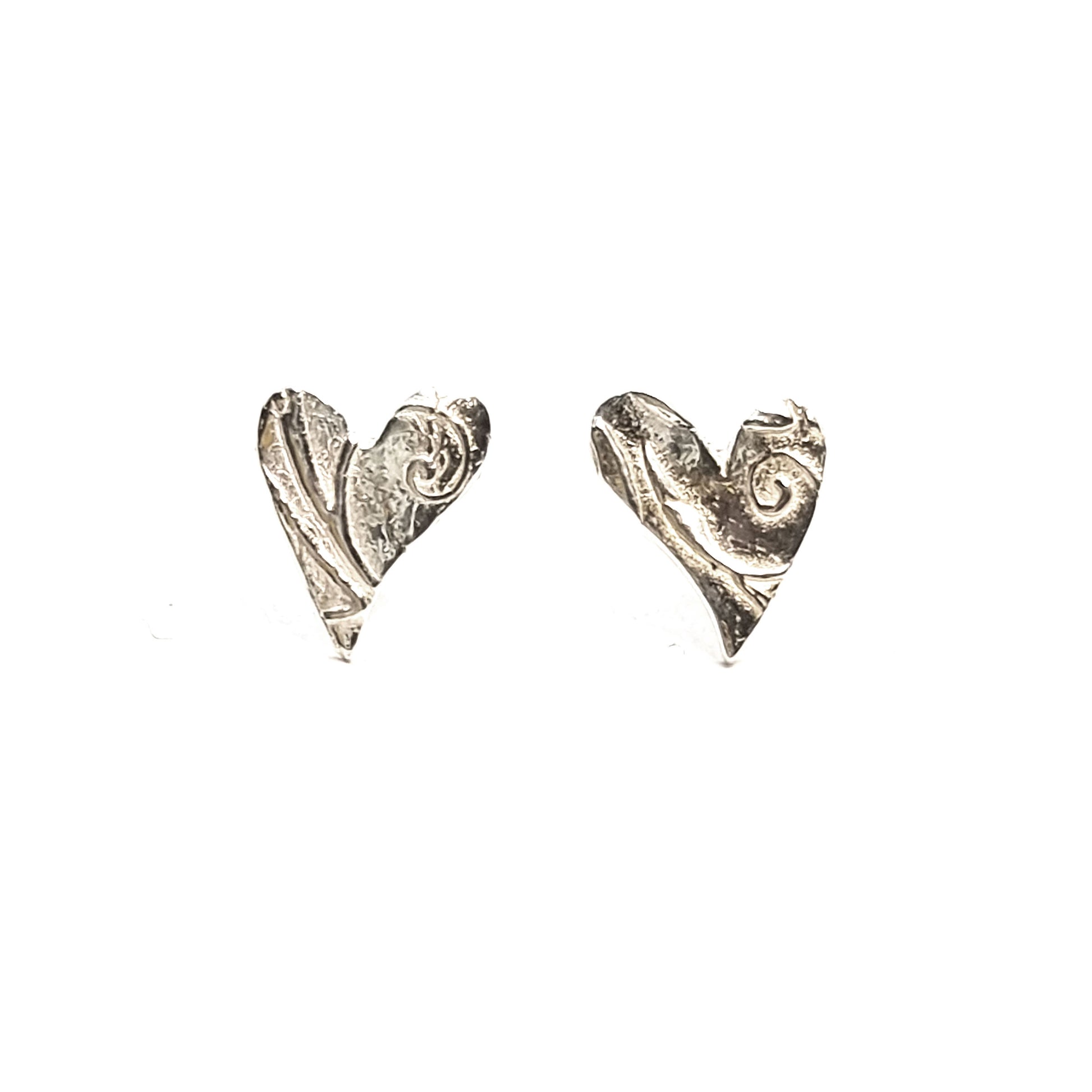 Silver asymmetrical heart stud earrings with a swirl pattern.