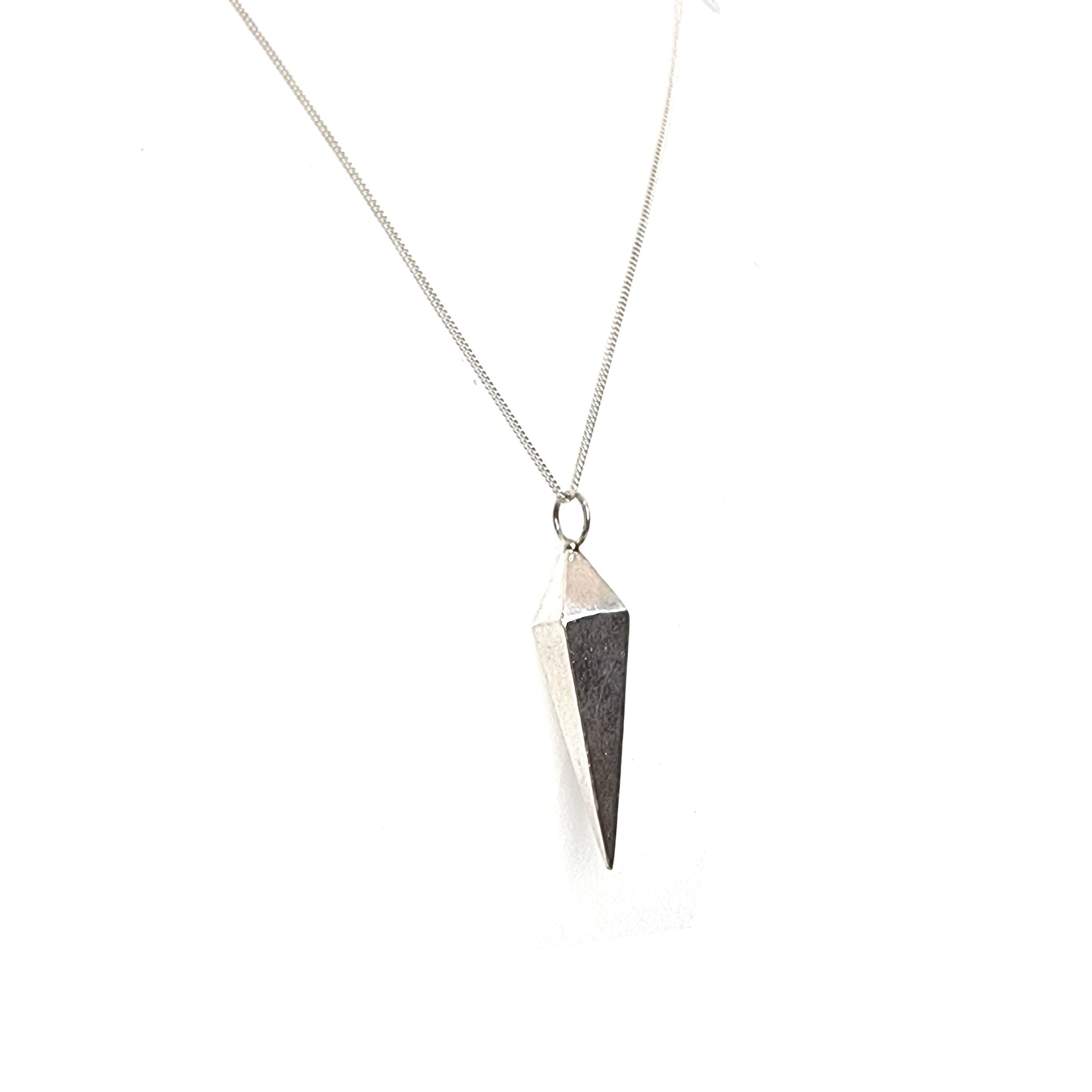 A silver geometric diamond shaped pendant on a silver chain.