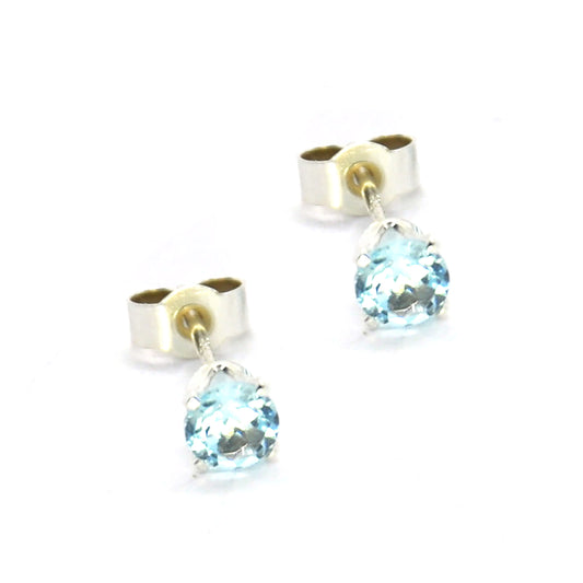 Silver 4 claw stud earrings with pale blue sky blue topaz round gemstones.
