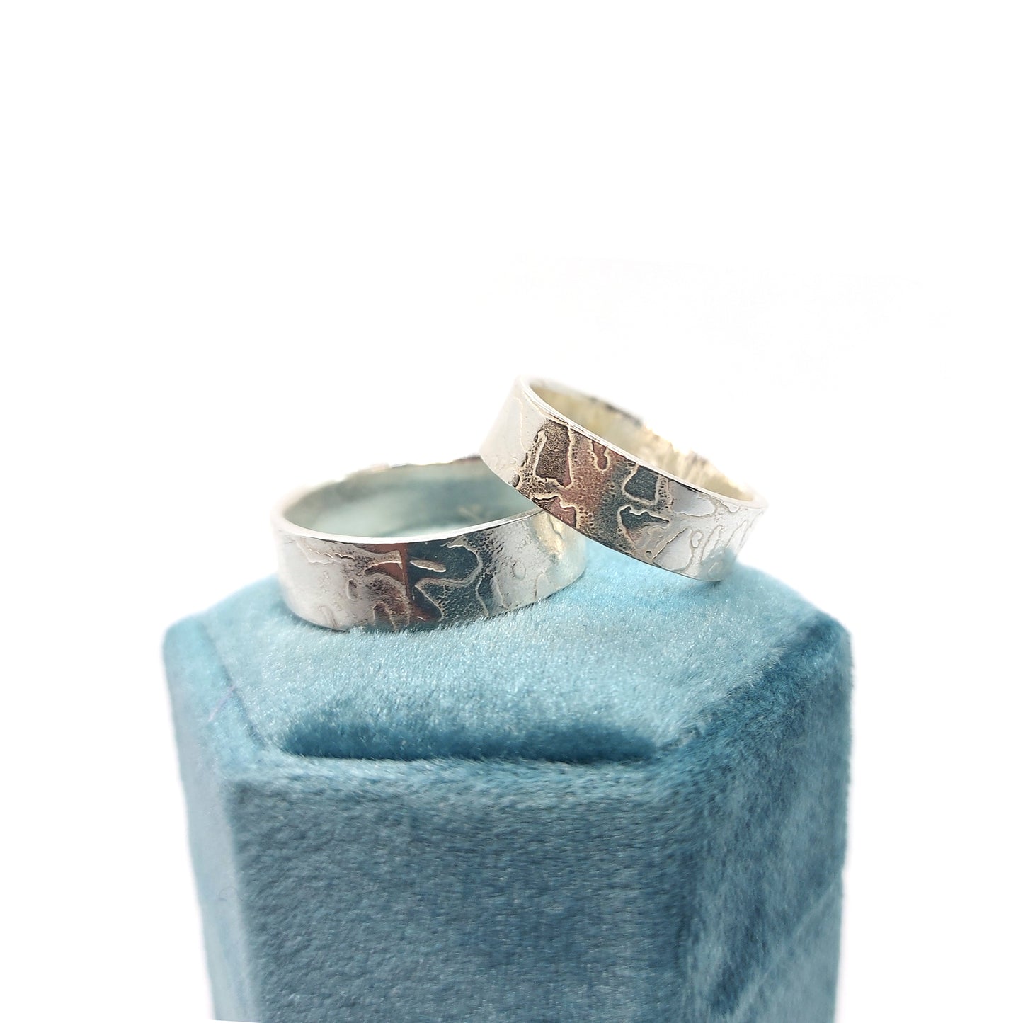 Two silver band rings with islands in the sea style pattern. His and hers.