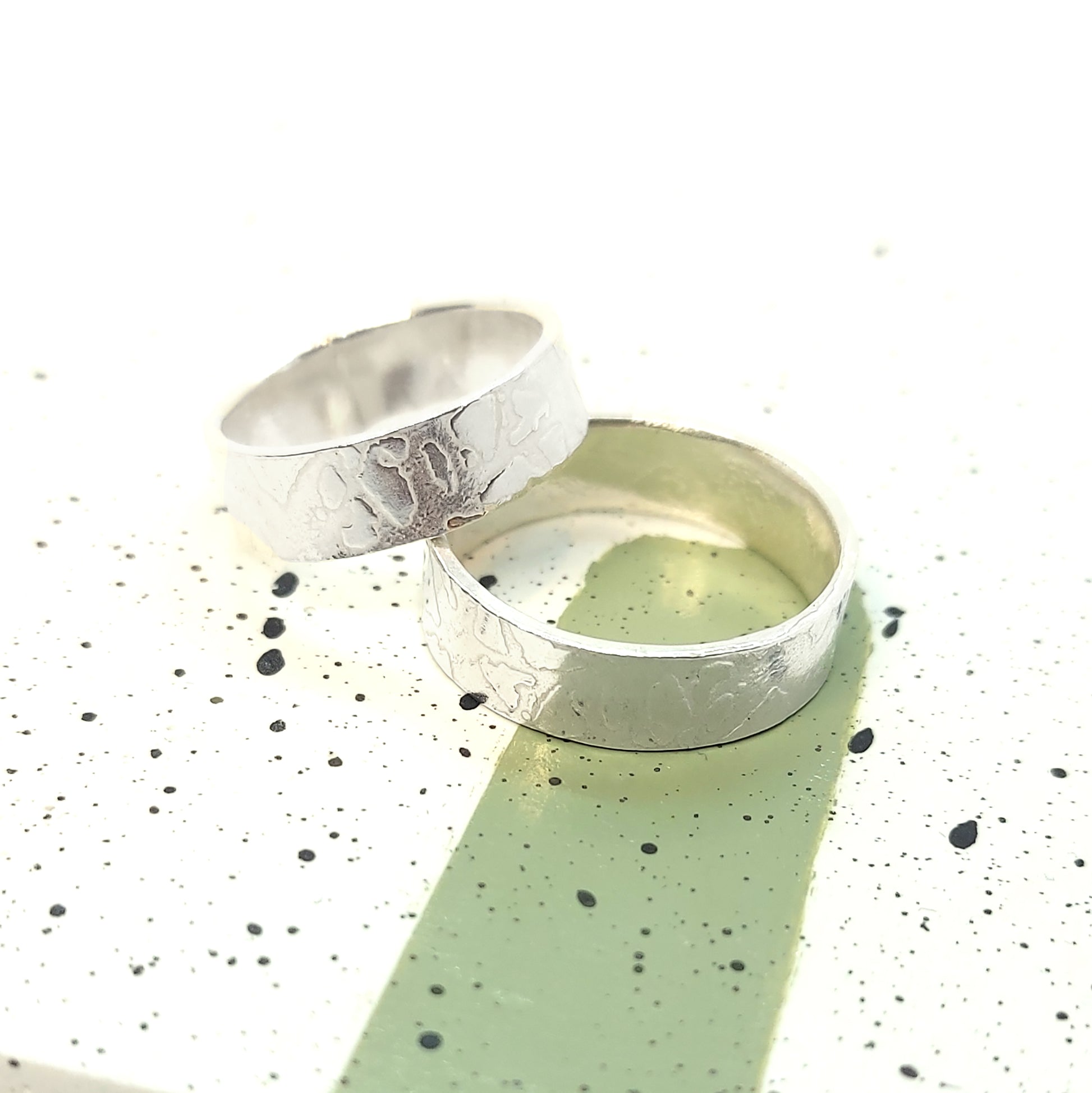 Two silver band rings with islands in the sea style pattern. His and hers.