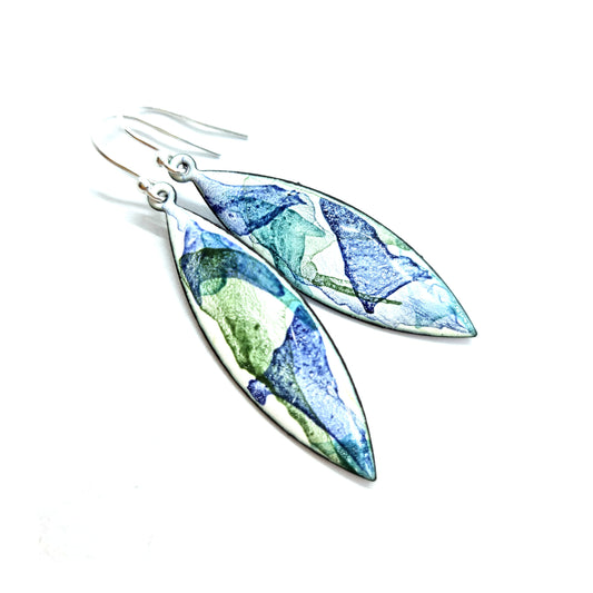 Navette shaped enamel drop earrings with splashes of green and blue on a white background