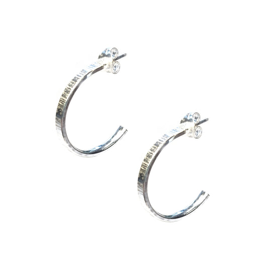 Silver flat hoop earrings with line texture.