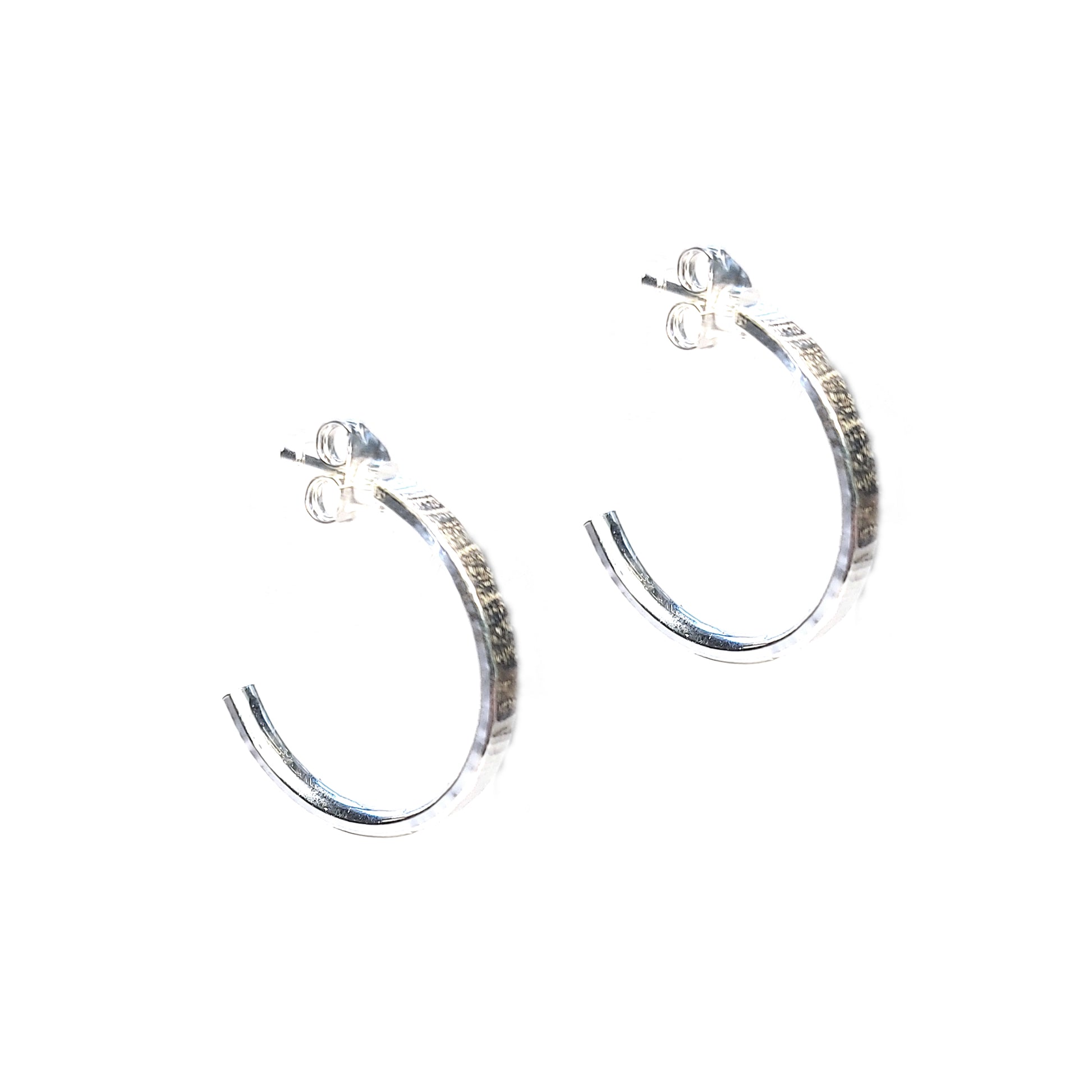 Silver flat hoop earrings with line texture.