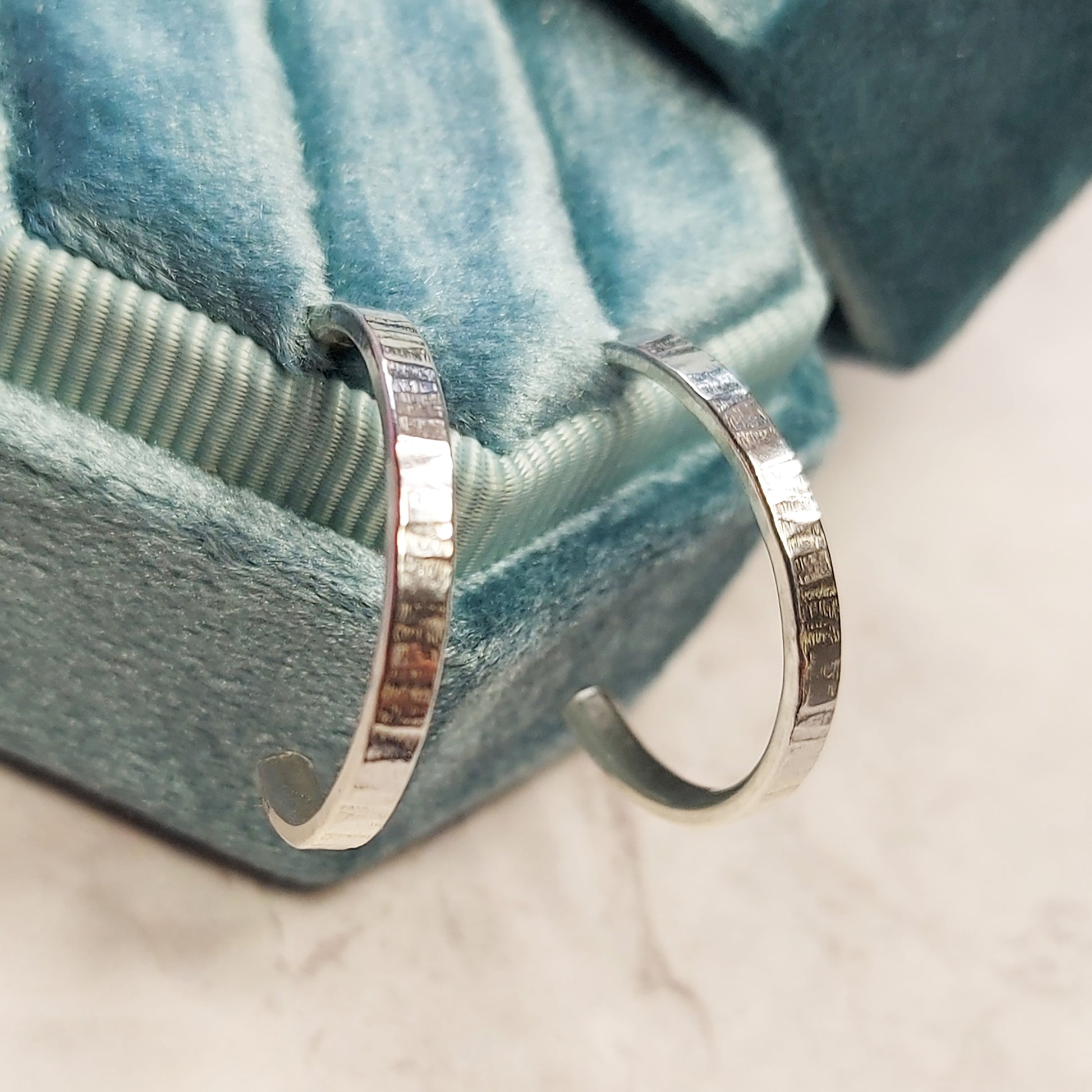 Silver flat hoop earrings with line texture in jewellery box