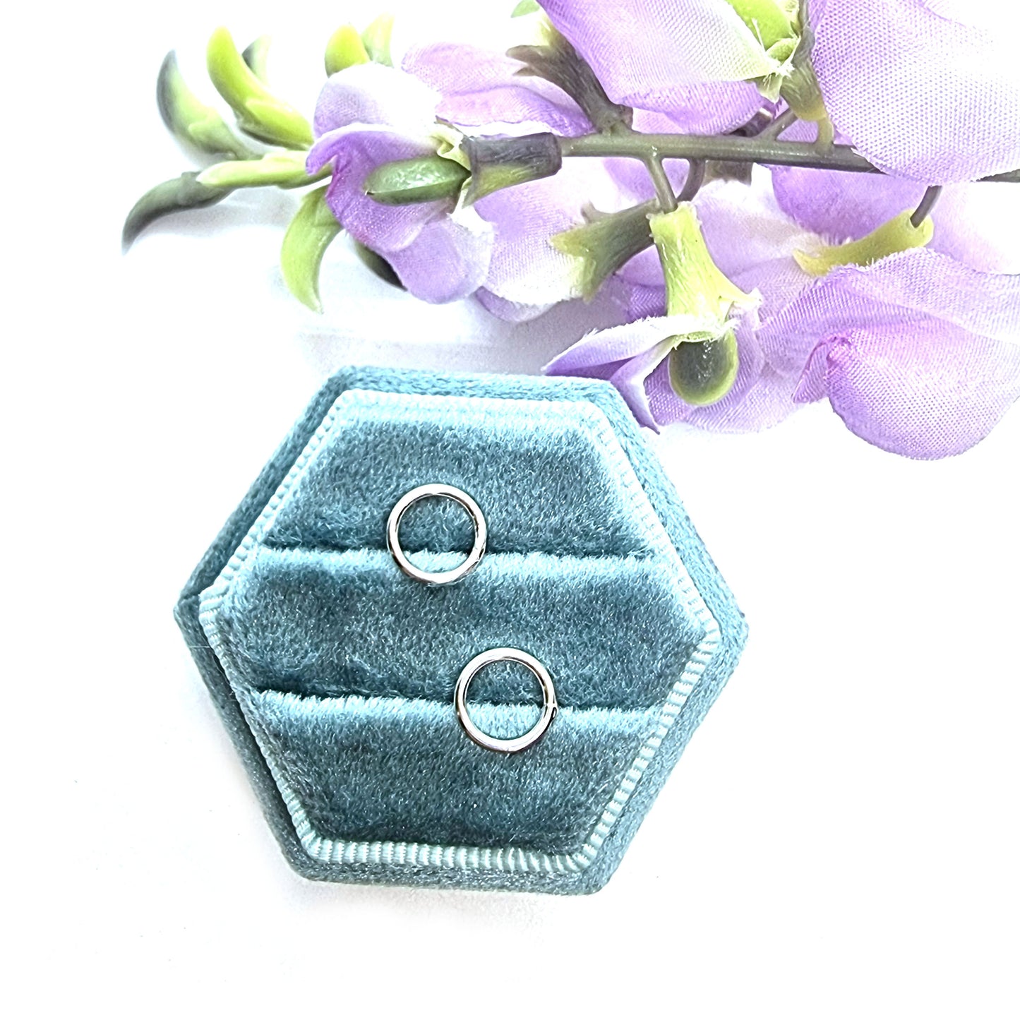 Sterling silver open circle stud earrings in jewellery box with flowers.