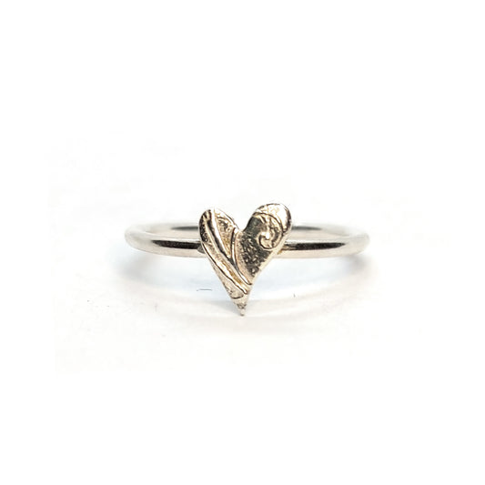 A handmade silver stacking ring with an asymmetric patterned heart in the centre. Mijoux Jewellery.