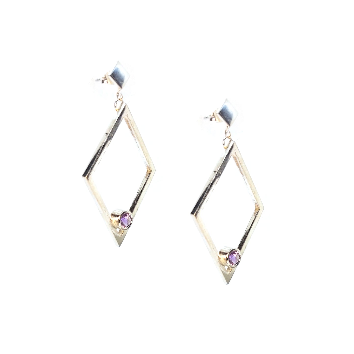 A pair of silver statement earrings featuring a top diamond shaped stud with a large open diamond shape drop beneath. Inside at the bottom of the large drop diamond is a round purple amethyst.