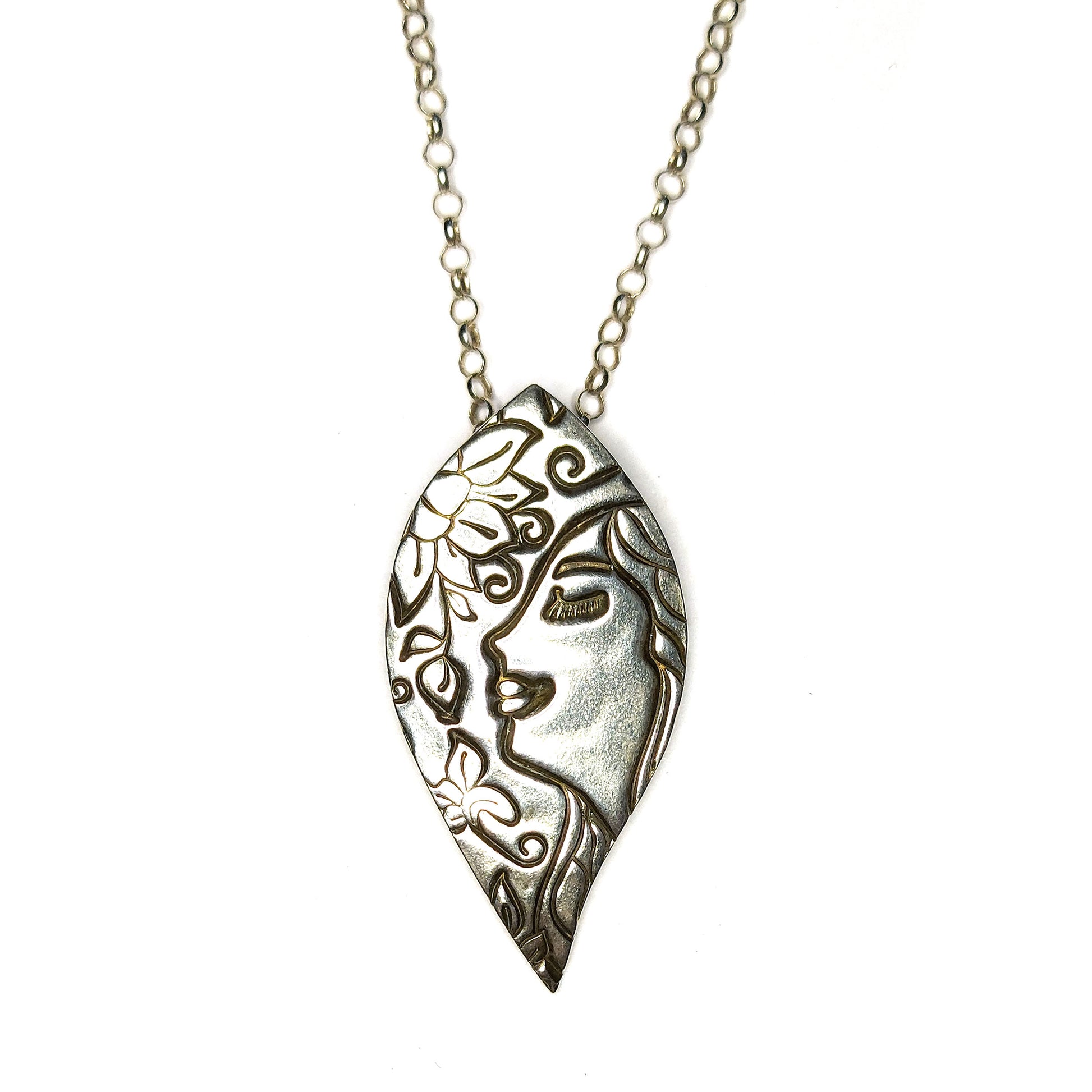 Silver leaf-shaped pendant on silver chain. The pendant features a smiling woman and a flower.