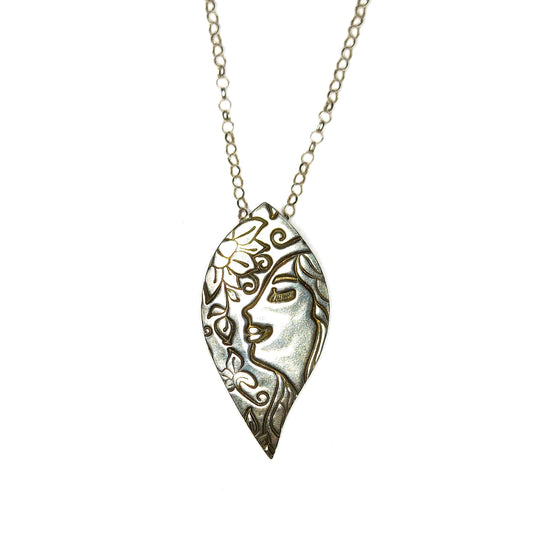 Silver leaf-shaped pendant on silver chain. The pendant features a smiling woman and a flower.
