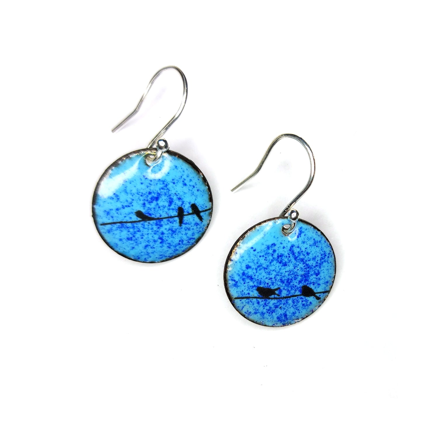 Round enamel drop earrings with blue background and black silhouettes of birds sitting on a wire.