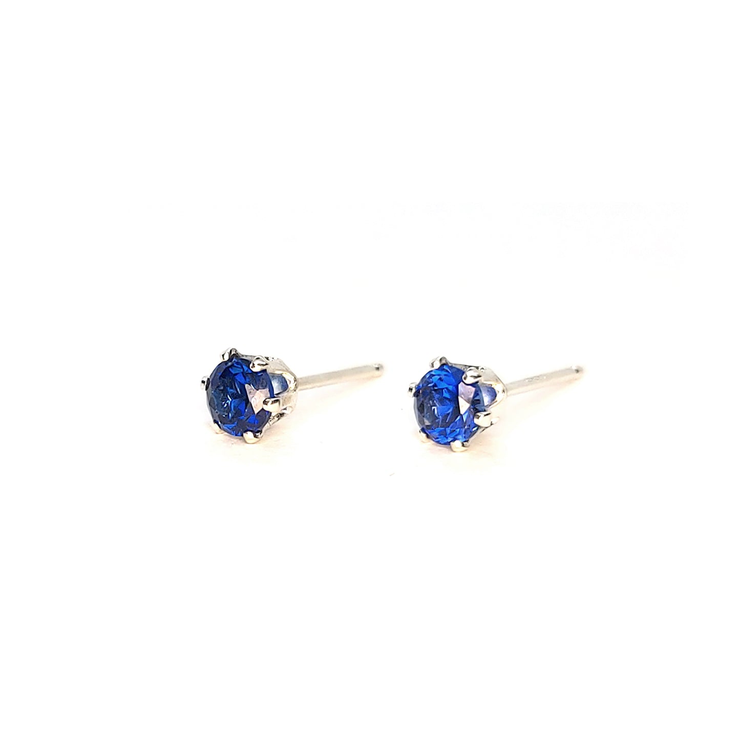 Silver 6 claw stud earrings set with dark blue sapphires. 4mm