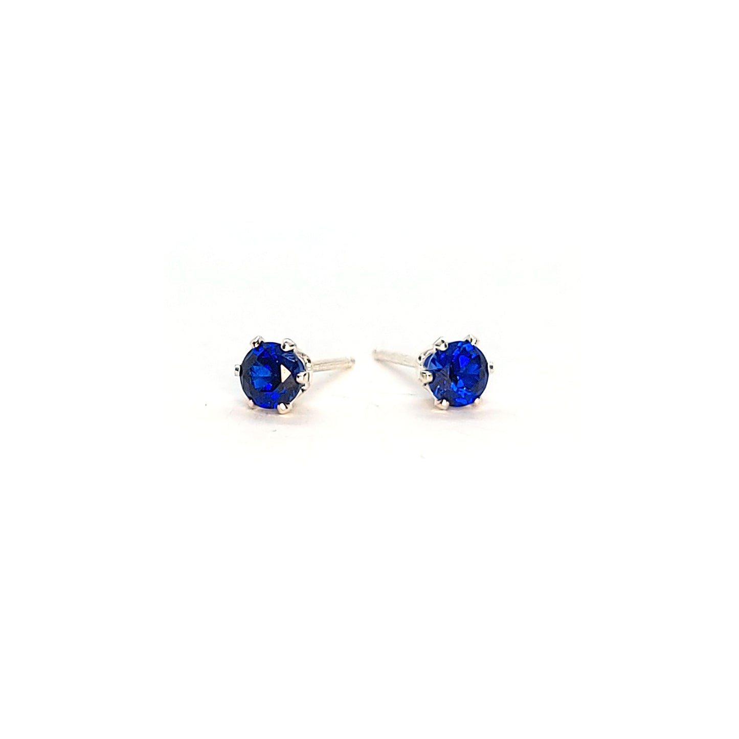 Silver 6 claw stud earrings set with dark blue sapphires. 4mm