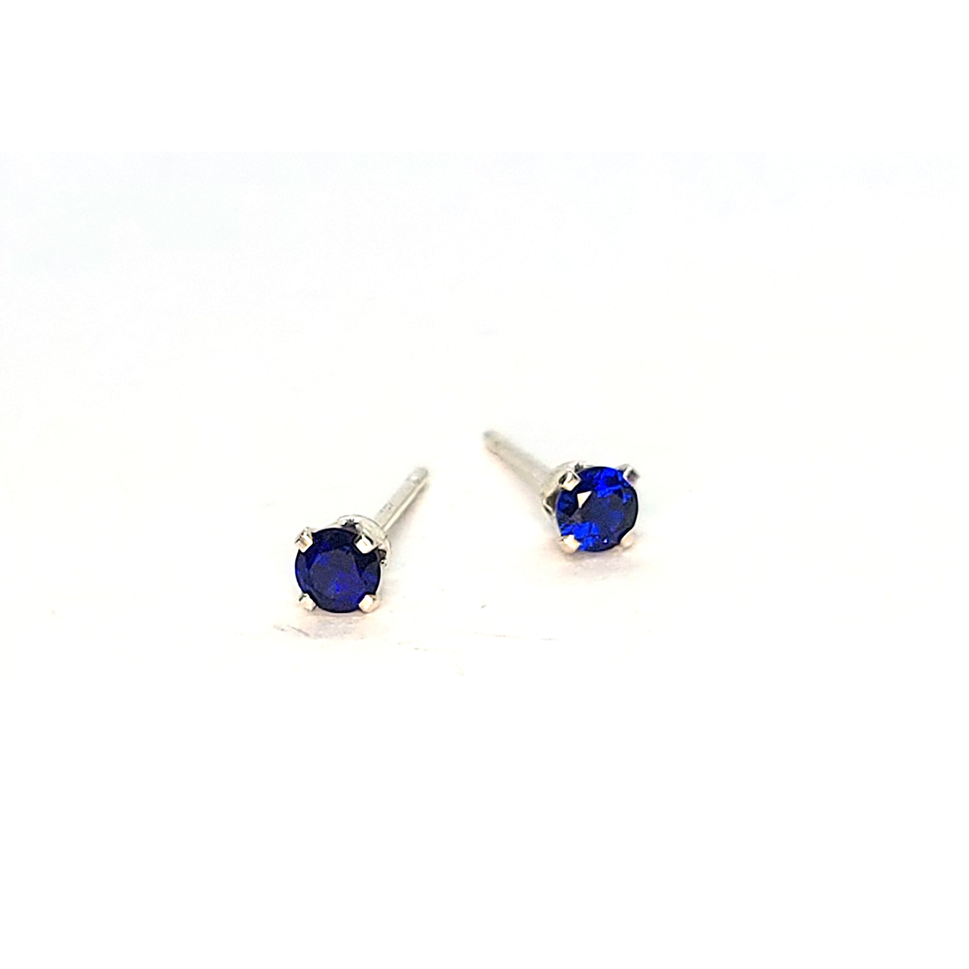 Silver 4 claw stud earrings set with dark blue sapphires. 3mm