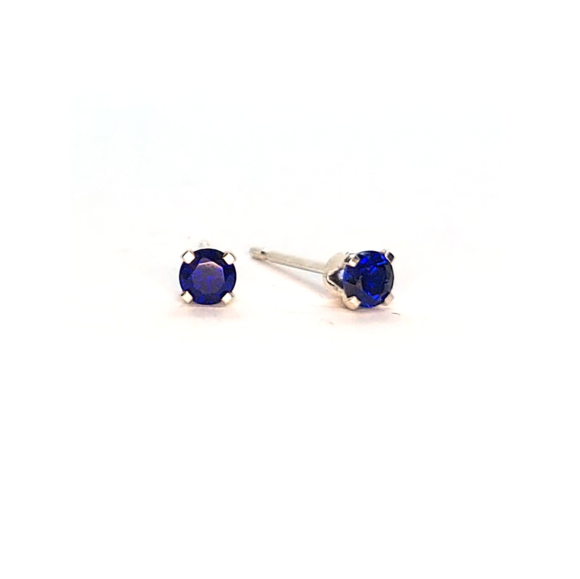 Silver 4 claw stud earrings set with dark blue sapphires. 3mm