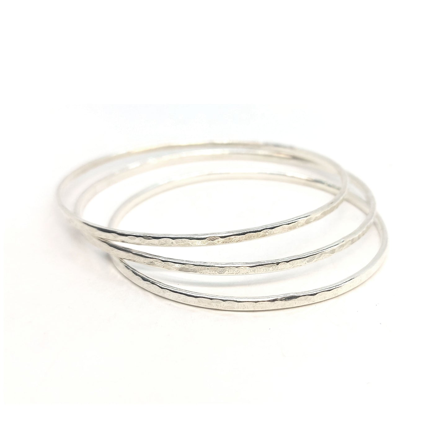 A stack of 3 silver hammered bangles