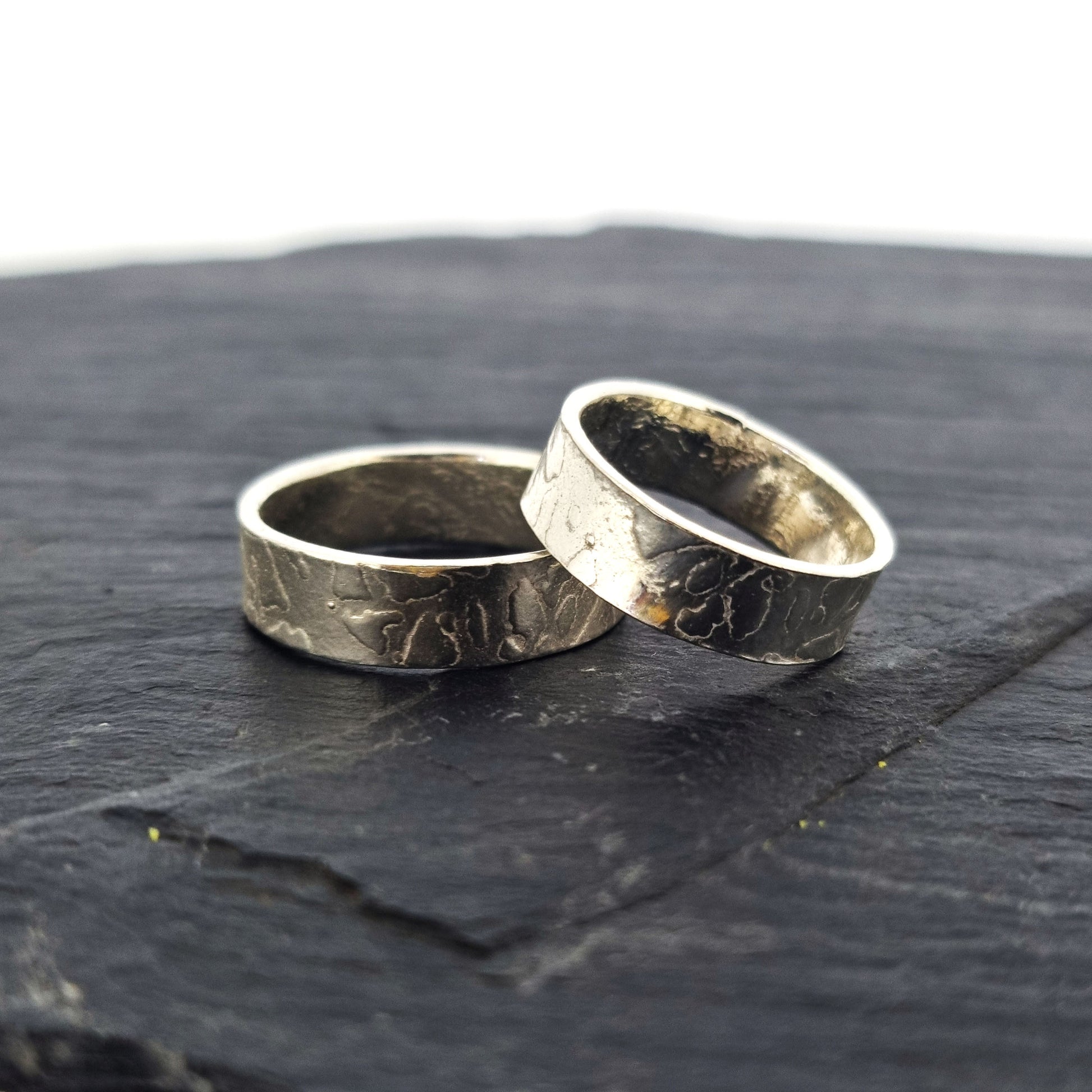 Two silver band rings with islands in the sea style pattern. His and hers.