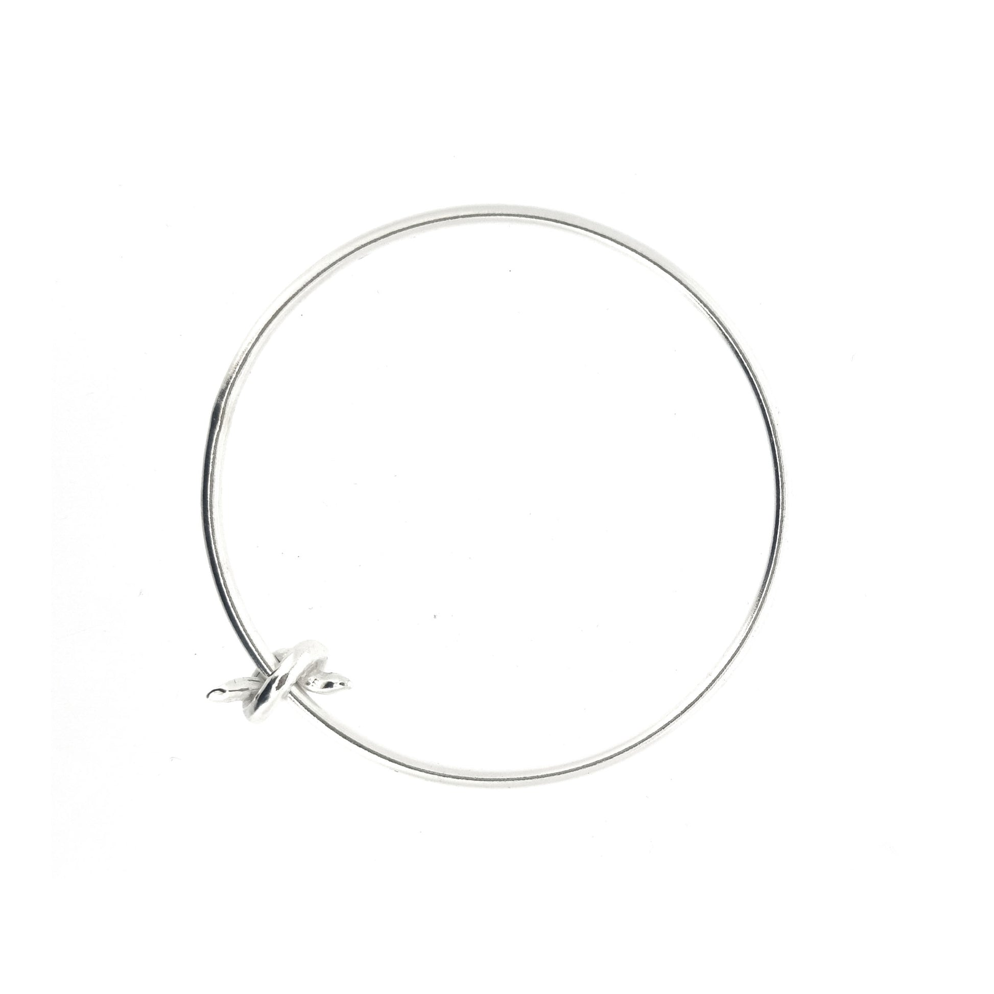Silver round bangle with spinning knot charm.