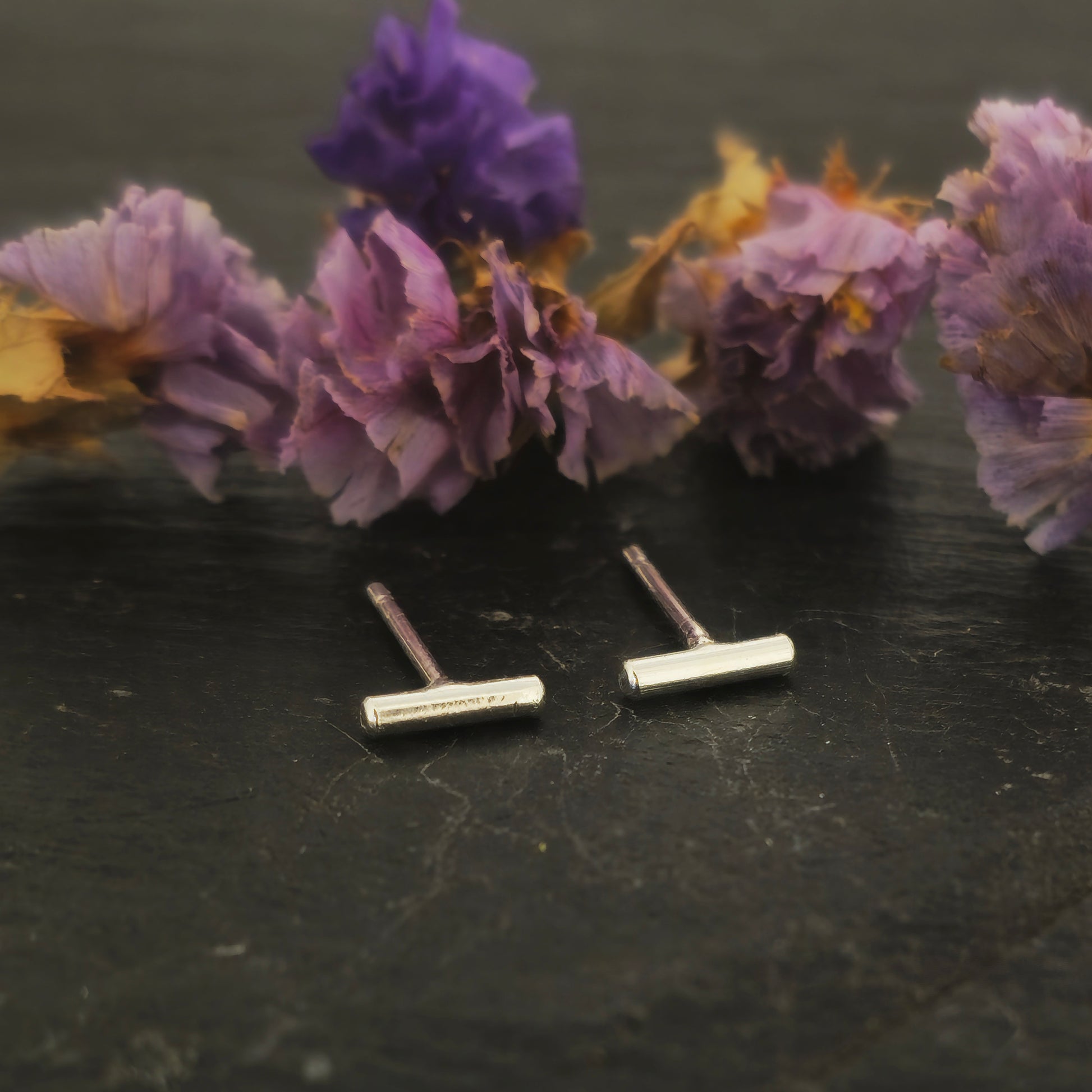 Silver bar stud earrings Pictured on slate with flowers.