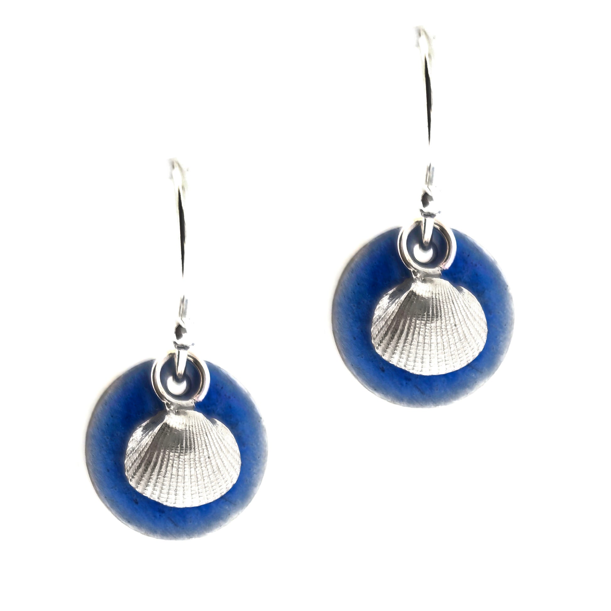 Pair of silver earrings with a blue enamel disc and a silver cockle shell on a white background. Handmade. Mijoux Jewellery.