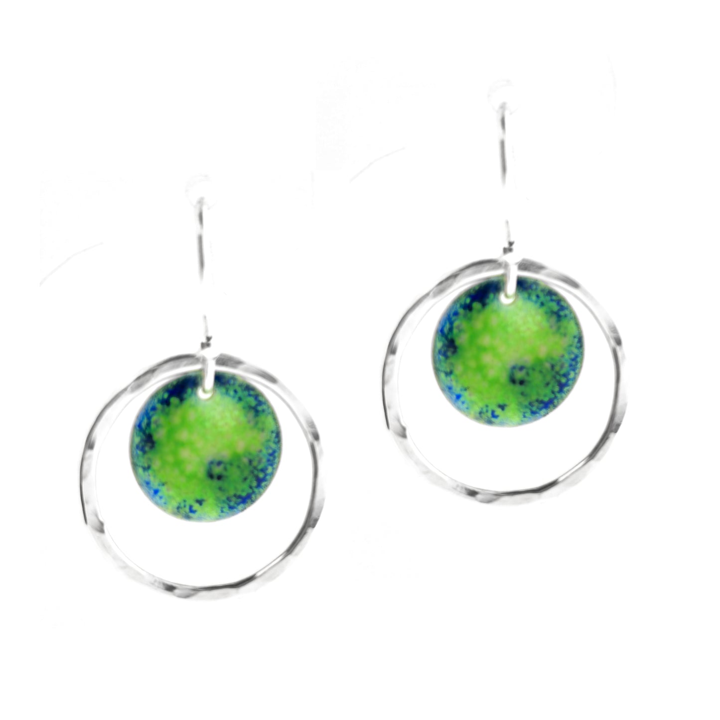 Silver drop earrings consisting of a central disc with a pattern of green and blue enamel surrounded by a silver circle with a hammered finish. On silver ear hooks.