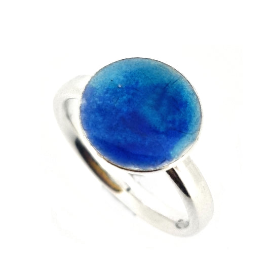 A silver ring band with a round silver top coloured with dark blue and turquoise blue enamel. 