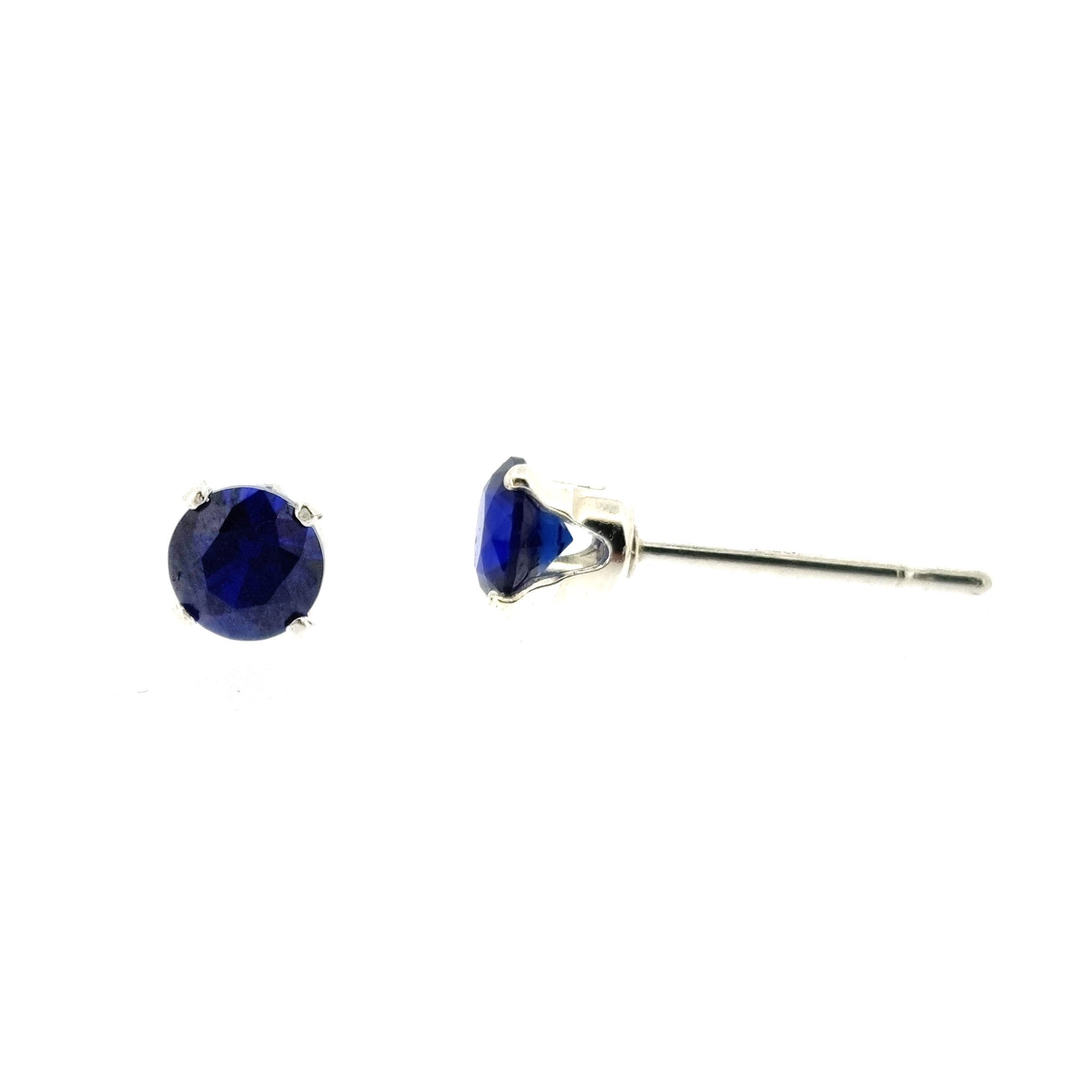 Silver 4 claw stud earrings set with dark blue sapphires. 4mm