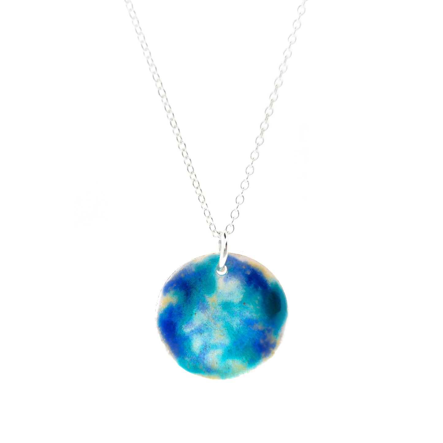 A round silver pendant on a silver chain. The pendant is covered in turquoise, blue and clear enamel.